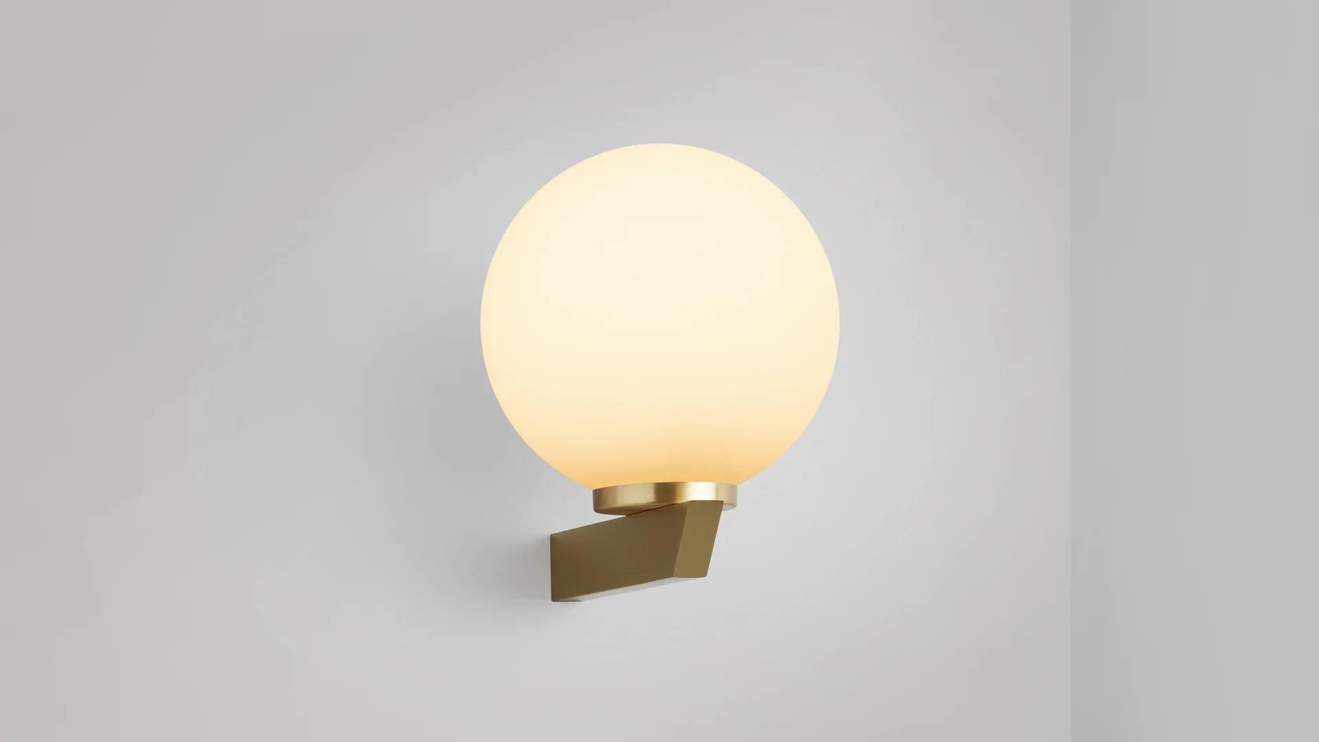 Gaia wall lamp by CTO Lighting
Materials: Satin brass with matt opal glass.
Dimensions: D 21.4 x W 15 x H 19 cm
Available in bronze or satin brass and in hand shaped smoke glass, matte opal glass, shiny opal glass, or tinted glass. 

An elegant
