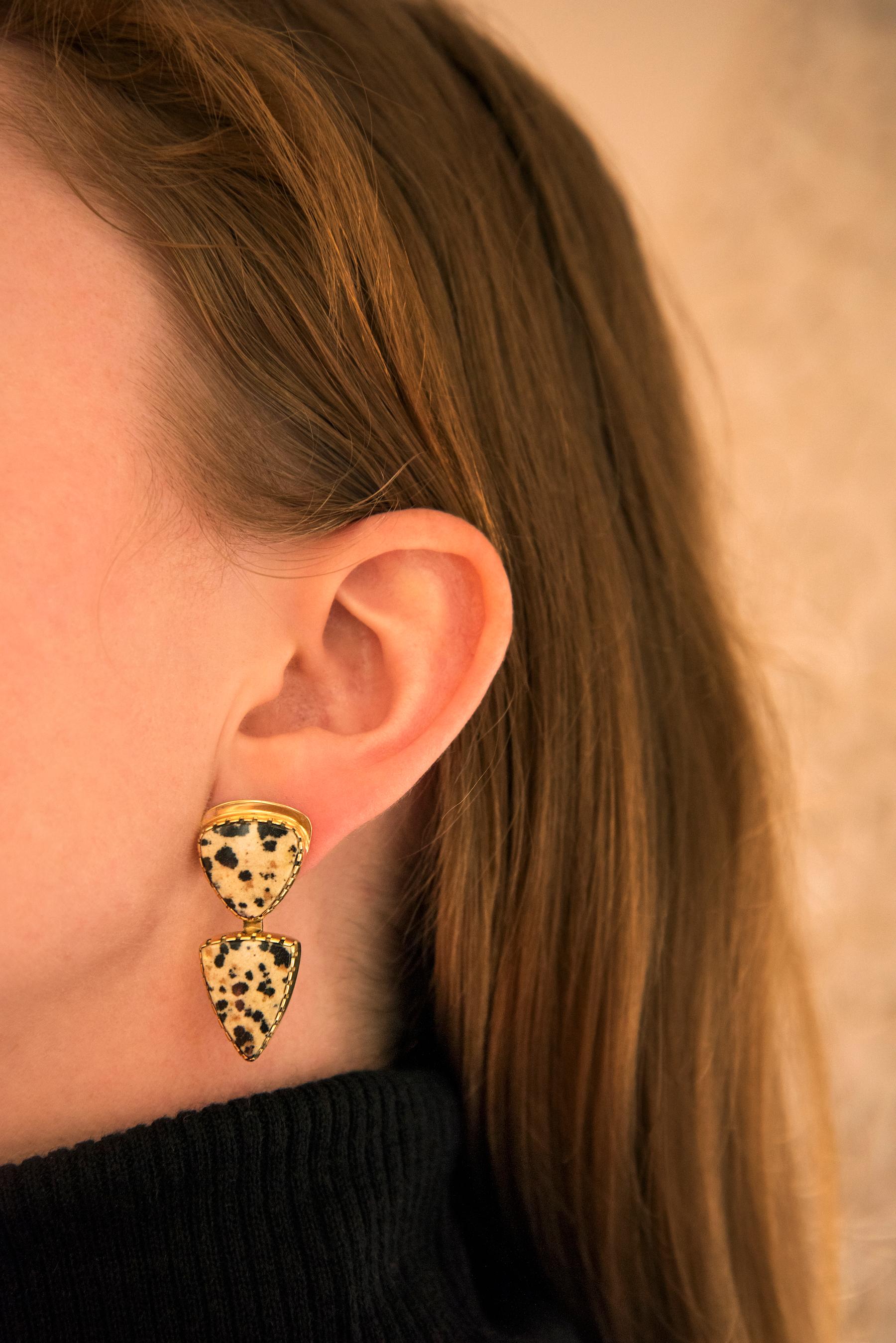 A pair of dalmatian jasper and 18 karat yellow gold earrings, by Gail Bird, Laguna Pueblo and Yazzie Johnson, Navajo, United States. The earrings are stamped with maker's mark (conjoined G and Y) and 18K.

These unique earrings are an excellent