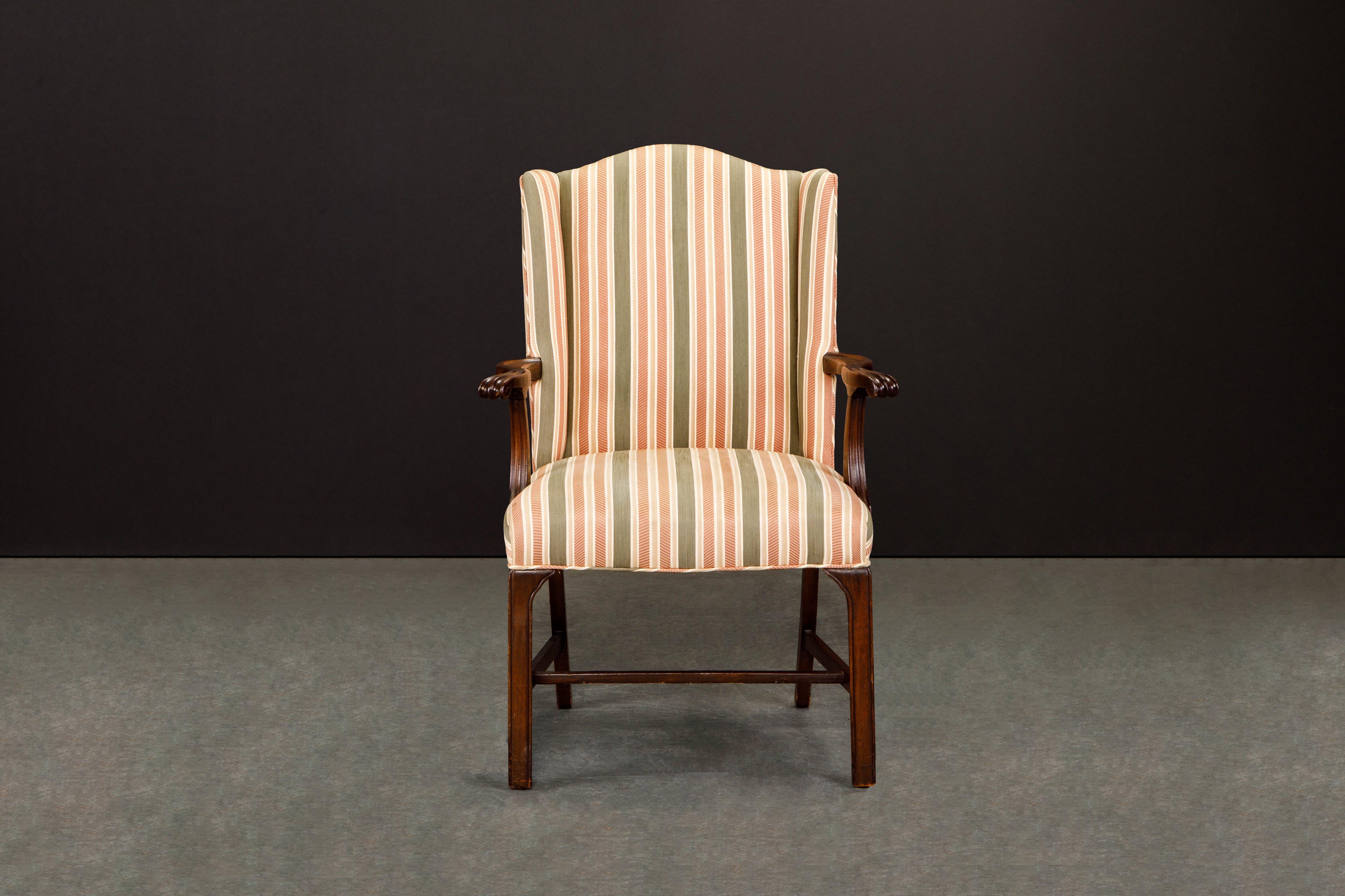 This beautiful Gainsborough style armchair with gorgeous carved wood arms are upholstered in a lovely striped fabric consisting of pinks, golds, green and off-white, featuring a subtle wingback design and in the Chippendale manner.

This antique