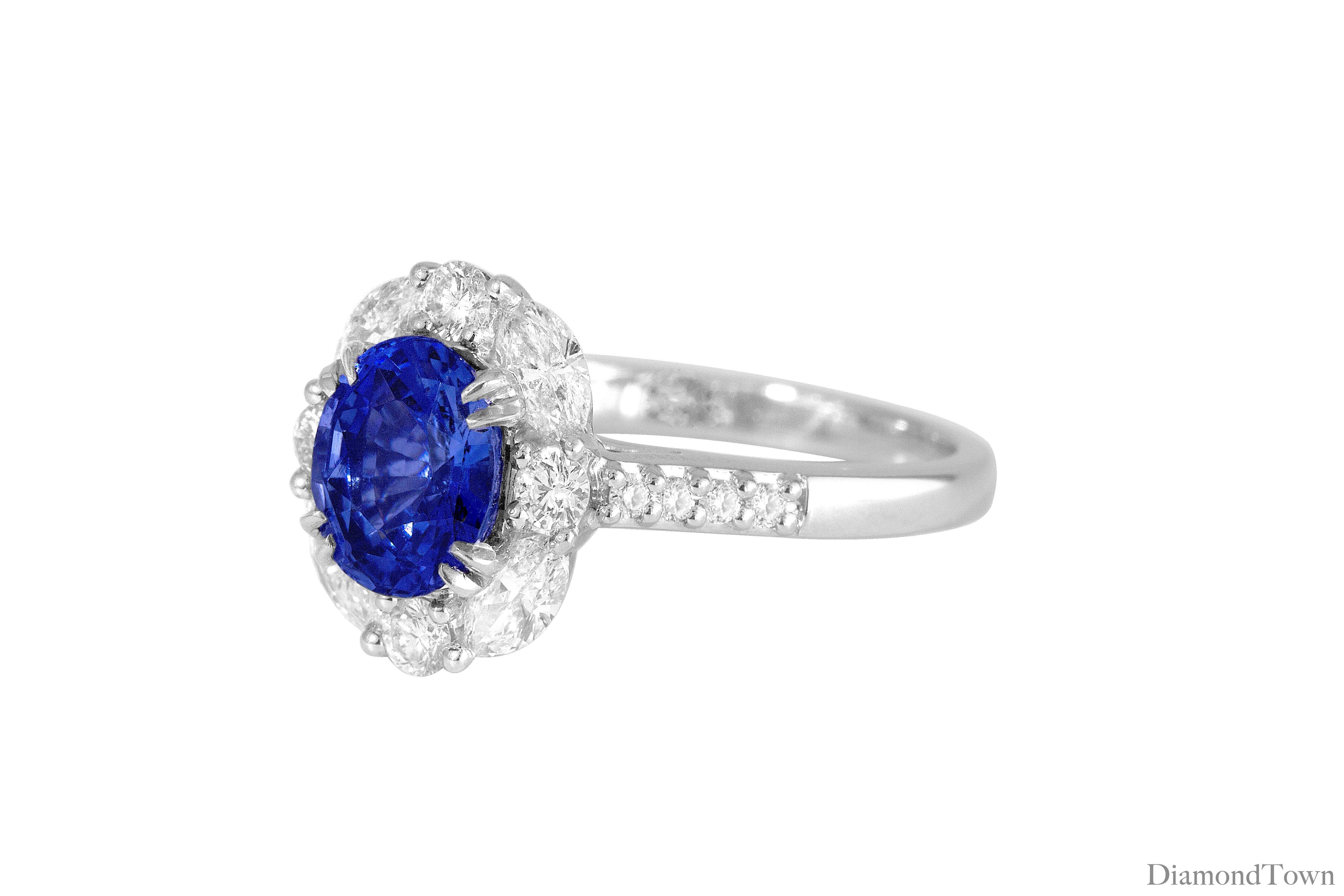 (DiamondTown) Dieser wunderschöne Ring hat einen GIA-zertifizierten Ceylon-Saphir im Ovalschliff mit einem Gewicht von 1,83 Karat, umgeben von einem Halo aus weißen Diamanten im Rund- und Marquise-Schliff. Zusätzliche Diamanten schmücken den