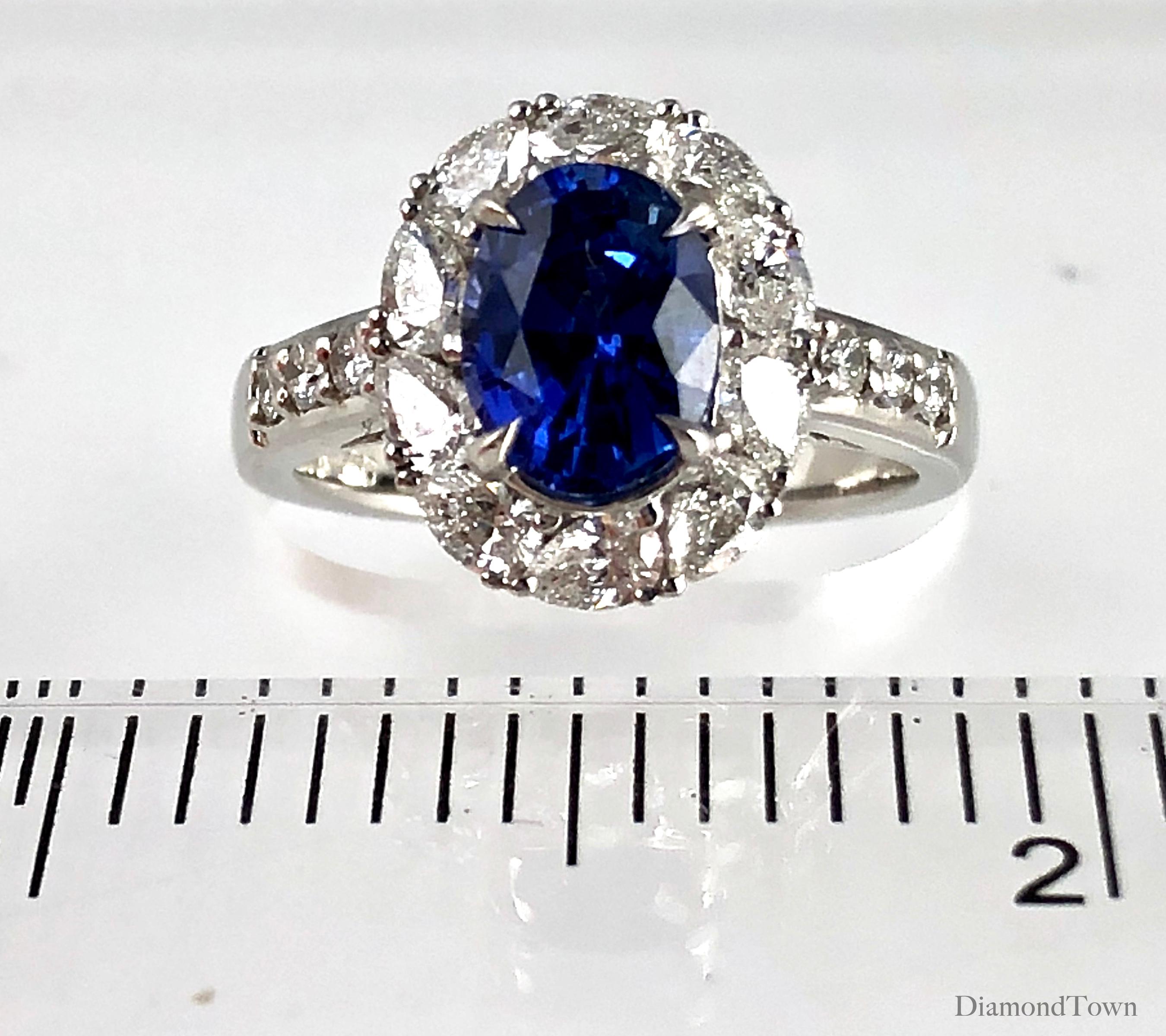 (DiamondTown) This handcrafted ring features a 1.84 carat Oval Cut Ceylon Sapphire center, surrounded by a halo of pear shaped diamonds. Additional round diamonds trail down the side shank, bringing the total diamond weight to 0.96 carats.

Ring