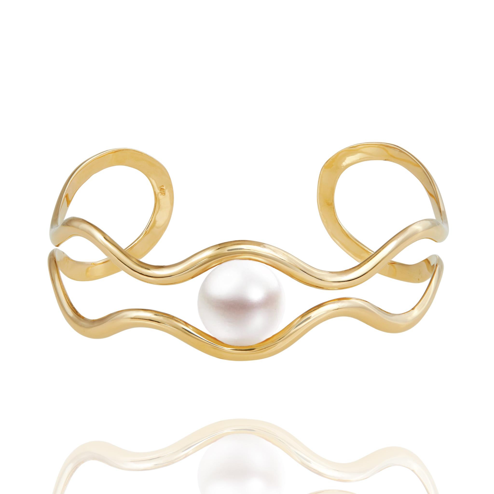 Il bracciale Gala 14k Gold Scallop Cuff with Pearl è un lussuoso pezzo di alta gioielleria realizzato in oro massiccio 14k con una perla d'acqua dolce di 13 mm.  Questo disegno astratto si ispira alla forma a smerlo di una conchiglia.  Taglie: polso