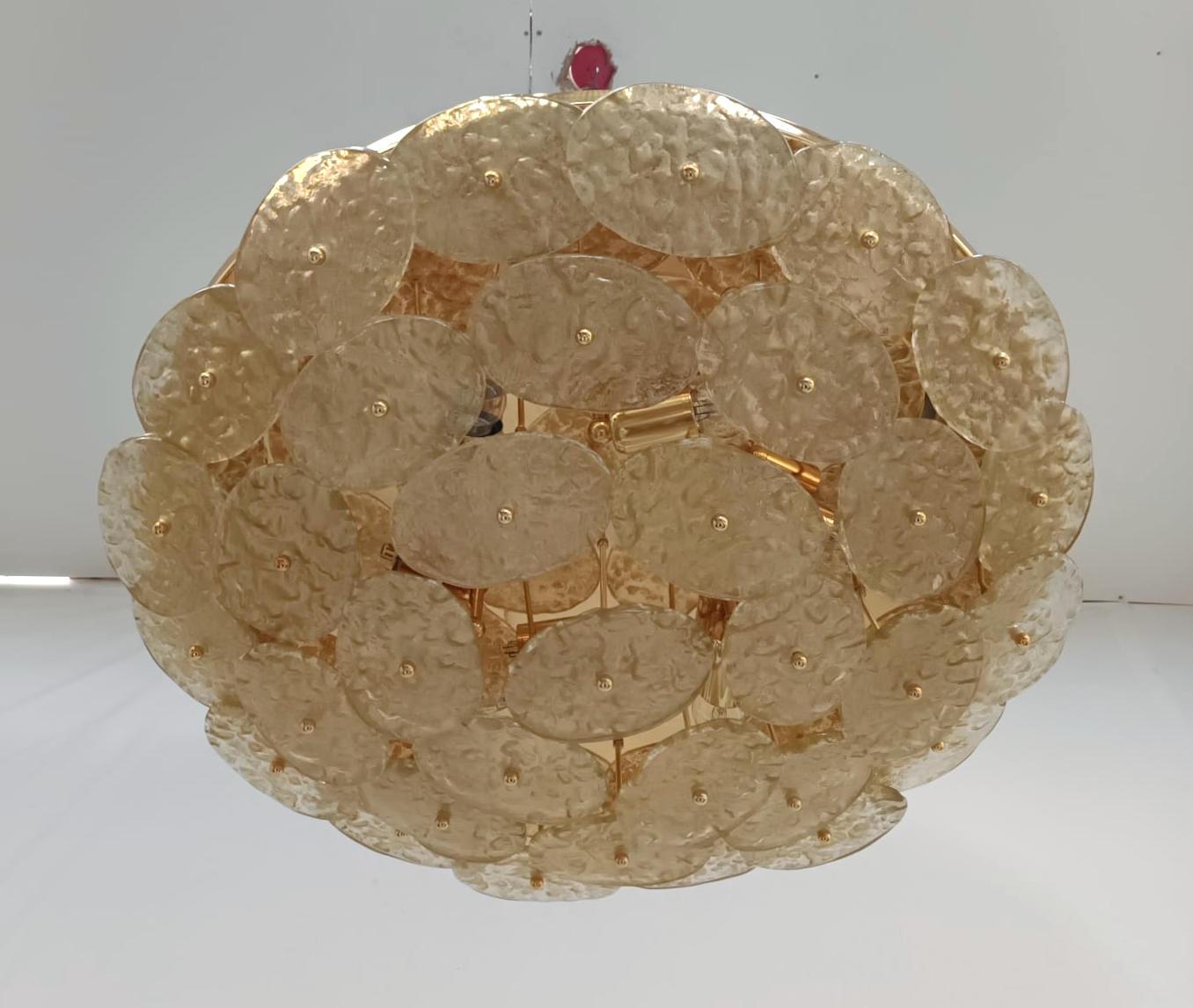 Italian flush mount with textured Murano glass oval discs in gold color, mounted on gold metal frame / designed by Fabio Bergomi for Fabio Ltd / Made in Italy
Measures: diameter 29.5 inches, height 7 inches
6 lights / E26 or E27 type / max 60W