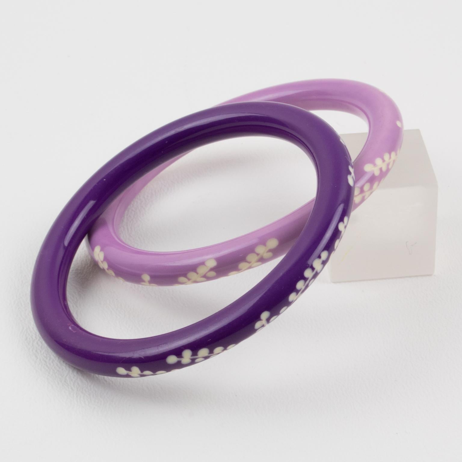 Lovely Galalith bracelet bangle, set of two pieces. Chunky spacer domed shape with deep floral carving all around. Assorted colors of purple lavender and amethyst purple over white background. 
Measurements for one bracelet: Inside across is 2.50