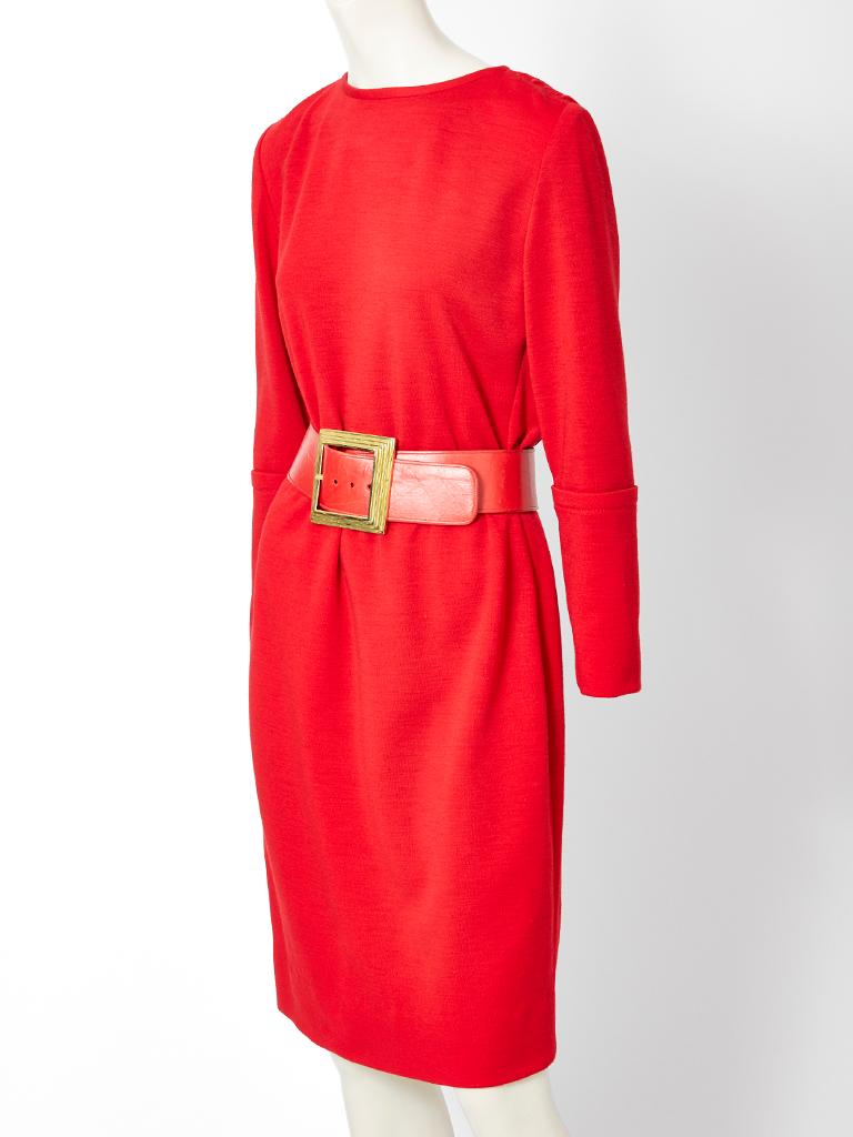 James Galanos, red, wool knit, shift-like day dress having long sleeves with a slightly dropped shoulder, jewel neckline and a gathered back detail with vertical slits at the upper bodice that exposes the skin. Red. wide, leather, curved  belt with