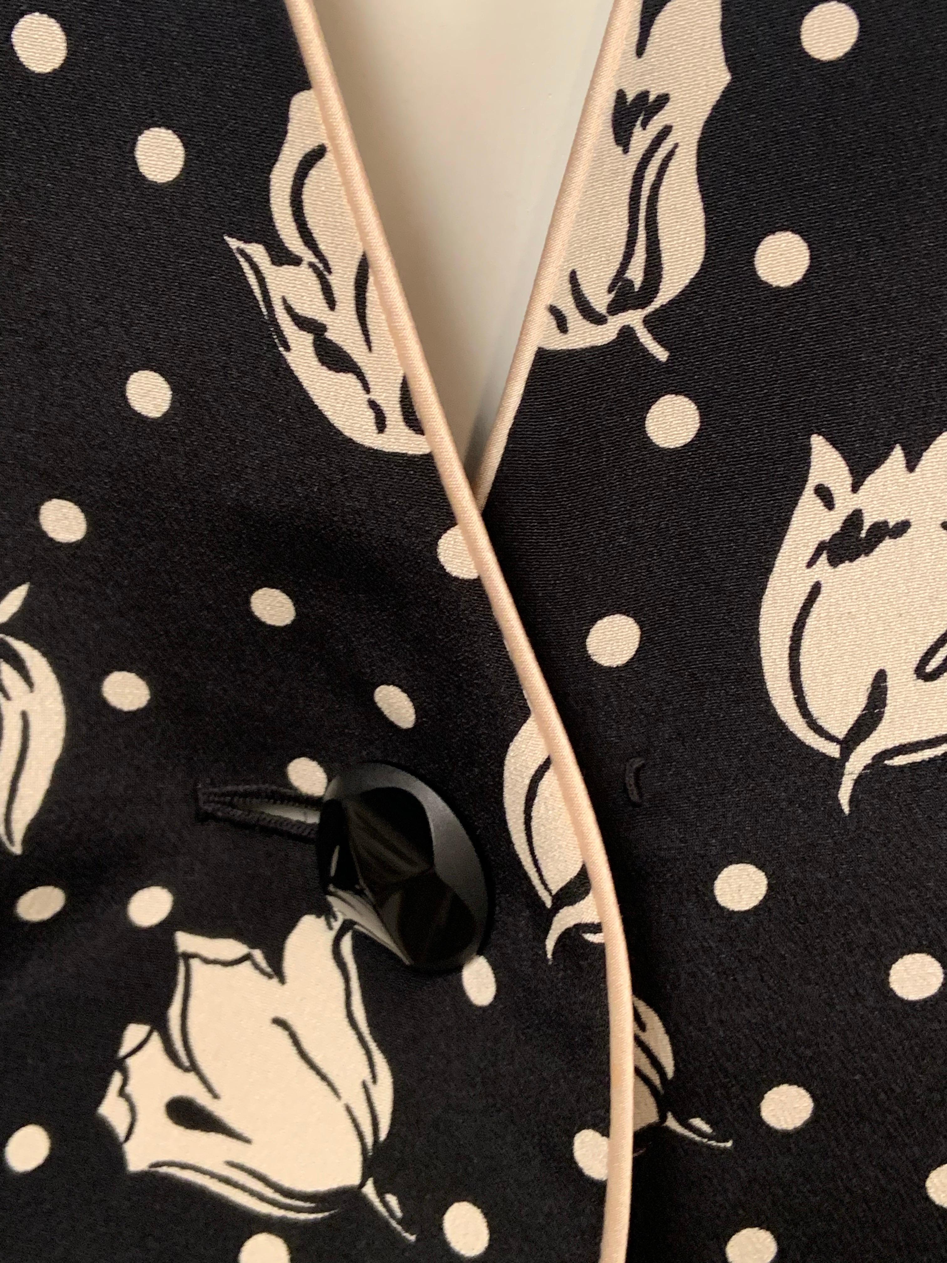 Diese charmante Jacke wurde in den 1980er Jahren von James Galanos entworfen und mit einem schwarz-weißen Seidendruck mit Tulpen und Tupfen versehen.  Die Seidenjacke ist am Halsausschnitt, in der vorderen Mitte und am Saum mit weißem Seidensatin