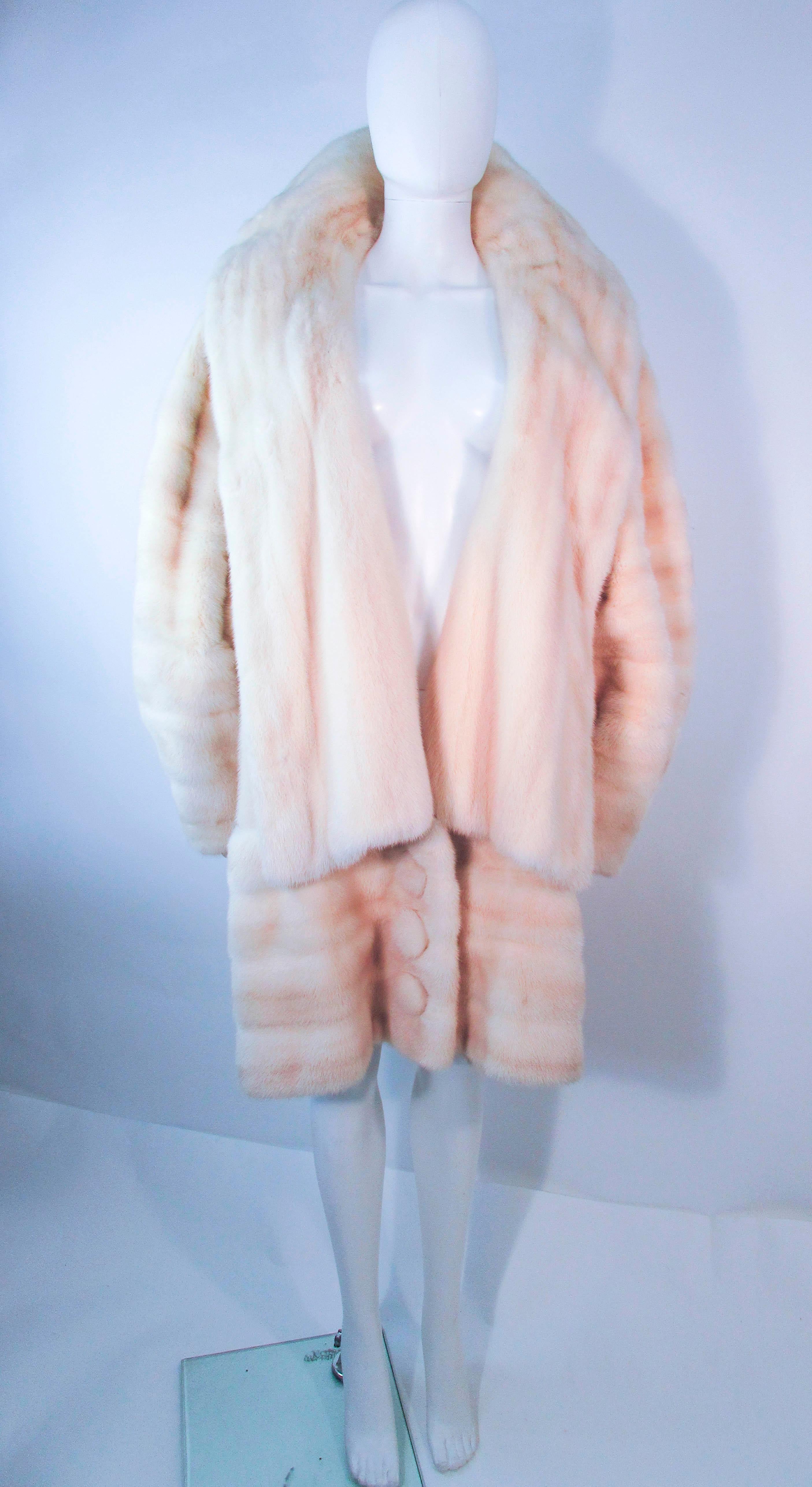 This is a wonderful Galanos coat which is composed of white mink, and features a large cascading collar with oversize balloon sleeves. There are three center front button closures. This is an absolutely lovely design with a large sweep of