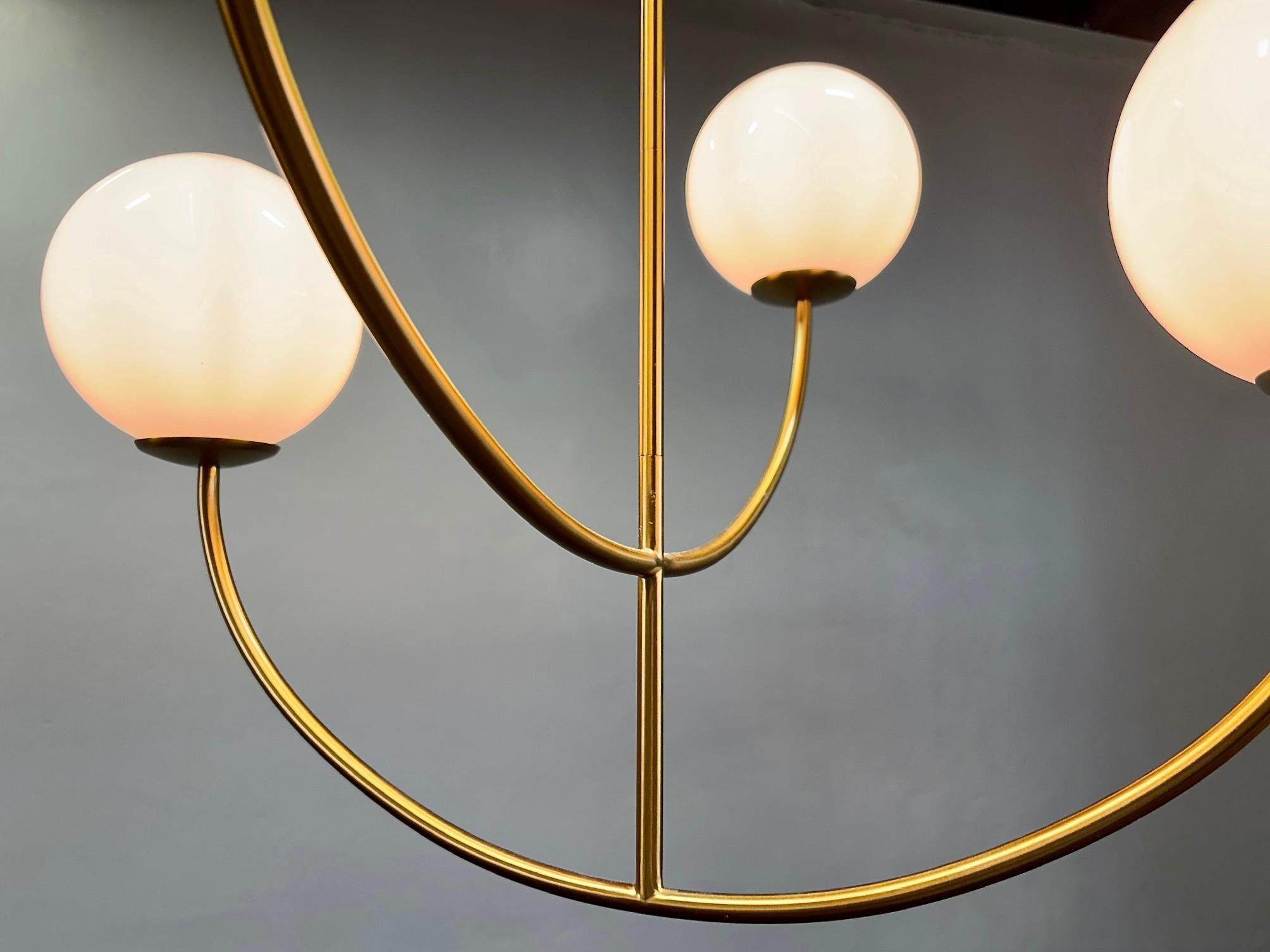 Lampadario Galassia di Visual Comfort, ispirato a una scultura cinetica. 4 lampadine sospese da bracci in acciaio con finitura in ottone brunito. Questo lampadario è una fusione senza sforzo di influenze della metà del secolo scorso e di belle arti.