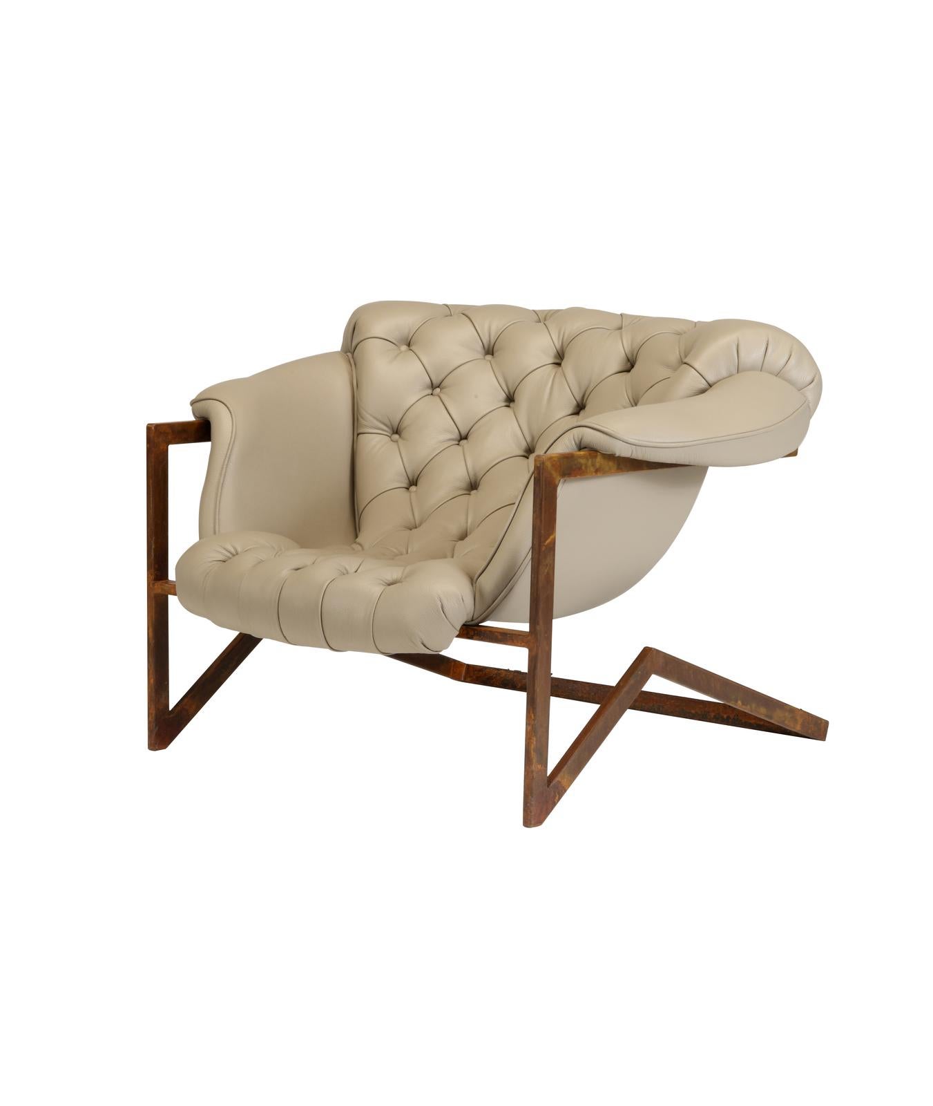 Este impresionante sillón, una elegante mezcla de materiales y estilos, tiene una base voladiza de hierro con un acabado marrón 