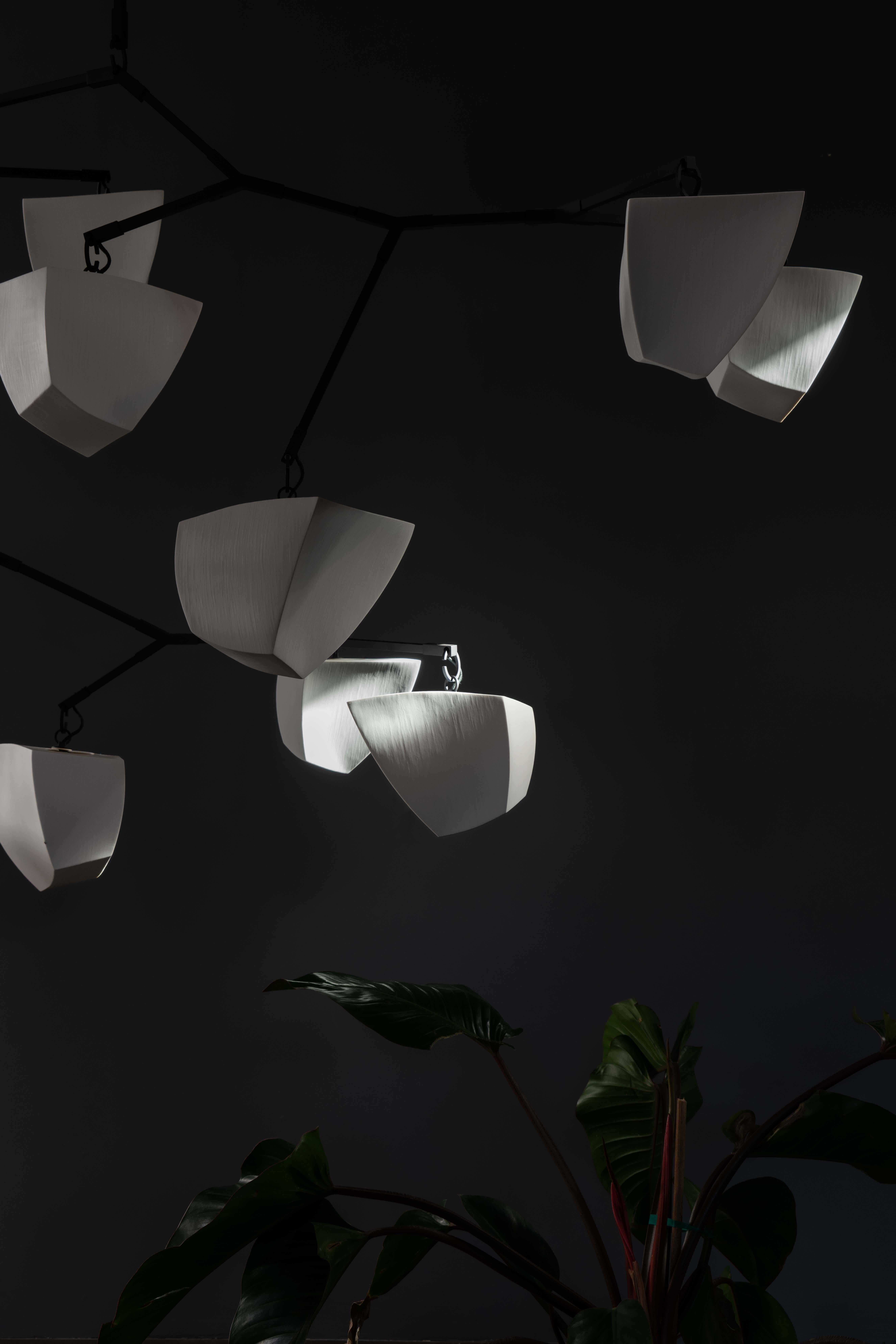 Le Porcelain Galaxy 25 est un lustre mobile à grande échelle composé de vingt-cinq abat-jour en porcelaine translucide fabriqués à la main et suspendus à quatre tiges distinctes. Cette pièce d'apparat apporte un mélange unique d'artisanat