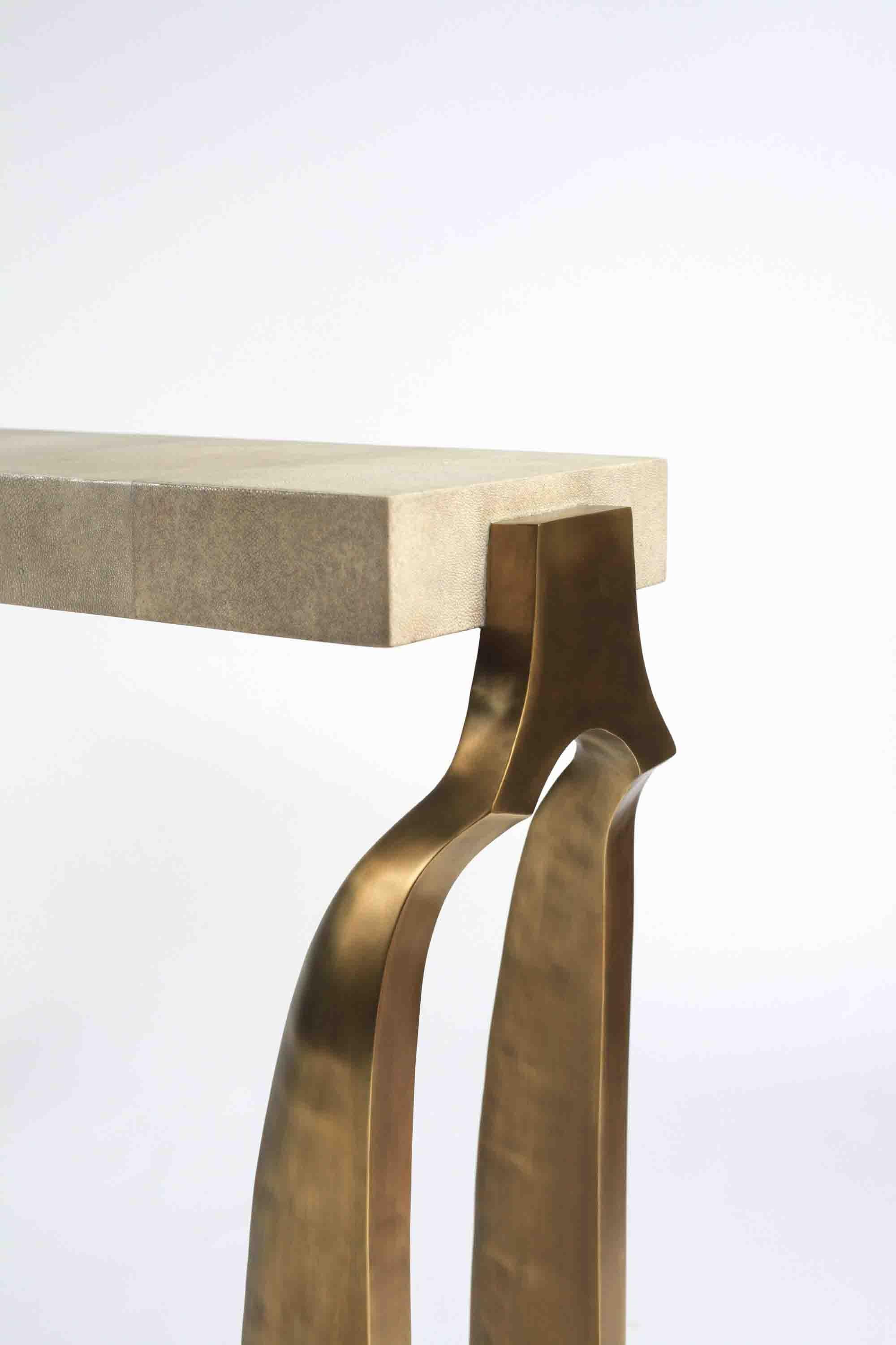 The Galaxy console table is both dramatic and organic it’s unique design. The cream shagreen inlaid top sits on a pair of ethereal and sculptural bronze-patina brass legs. This console table also comes in a writing desk version, see image at end of