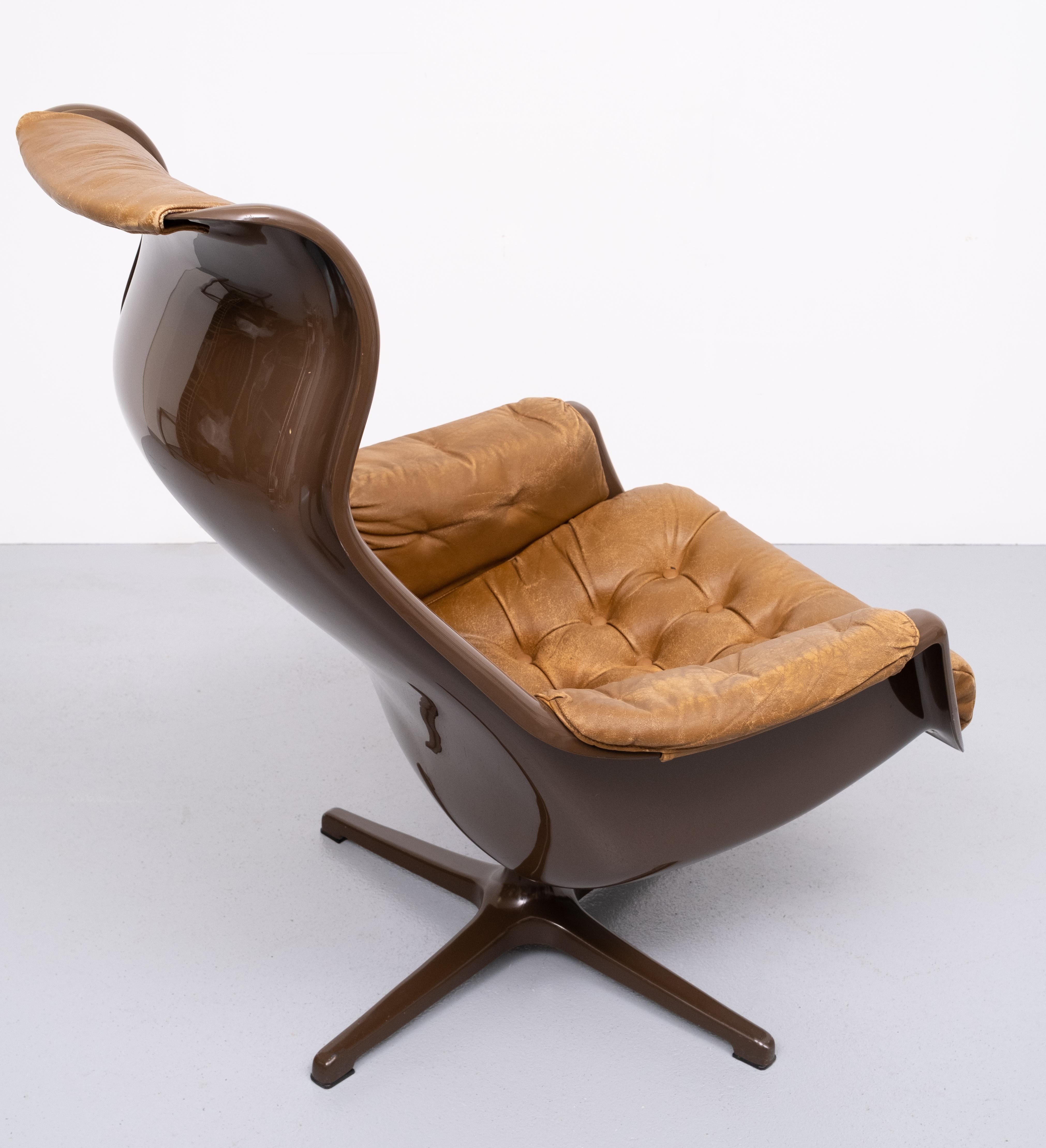 Nice Space Age curved galaxy lounge chair. The armchair features a dark Brown plastic body with a Leather Cognac color removable upholstery and an aluminum tunable base. The armchair was designed by v and Yngvar Sandström and manufactured by DUX, in