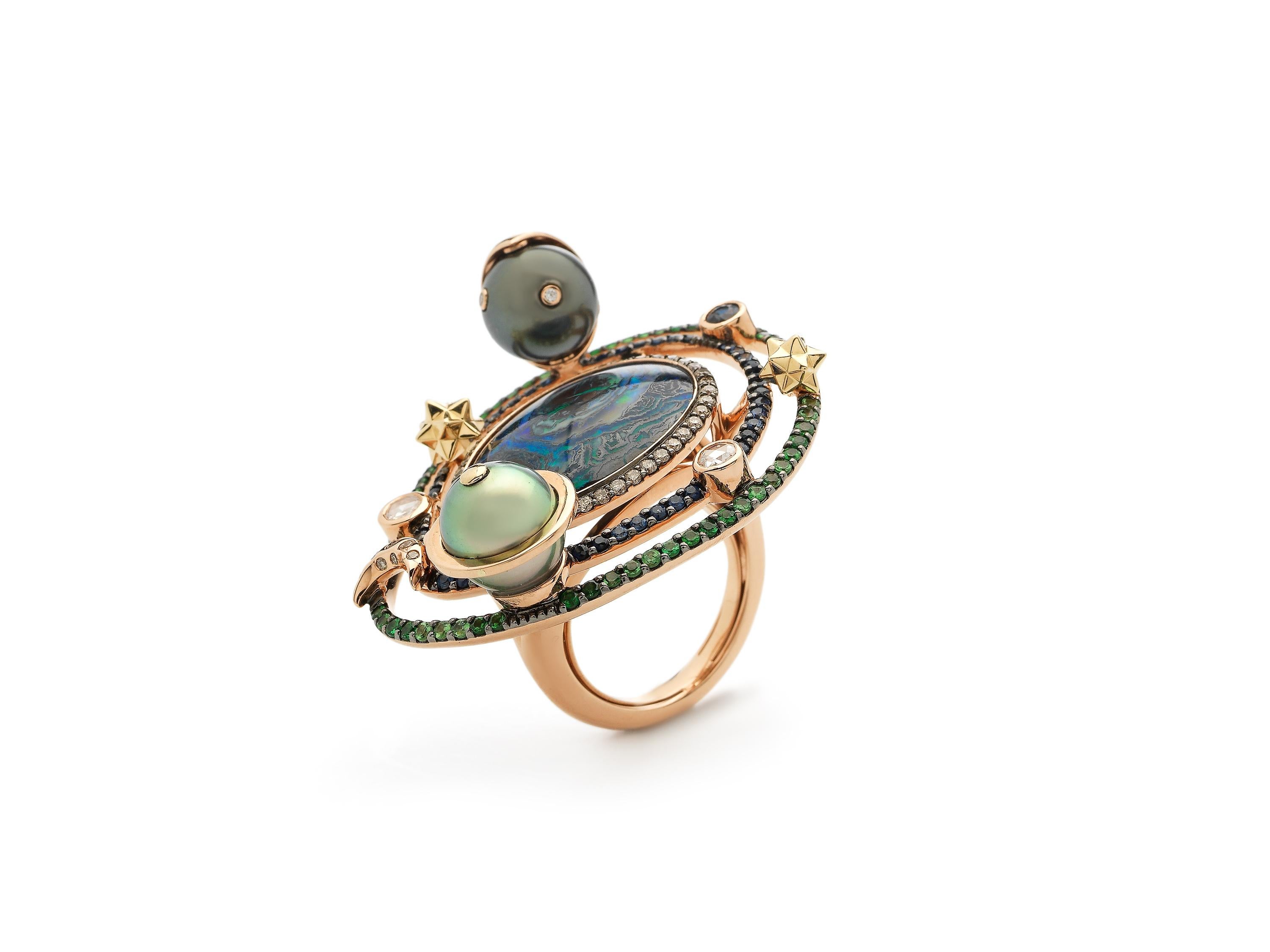 Bibi creates a miniature universe in this statement ring. At its center is a boulder opal that Bibi has chosen specifically for its unique colors and inclusions, that evokes the look of a swirling galaxy. Circling the opal are small planets,