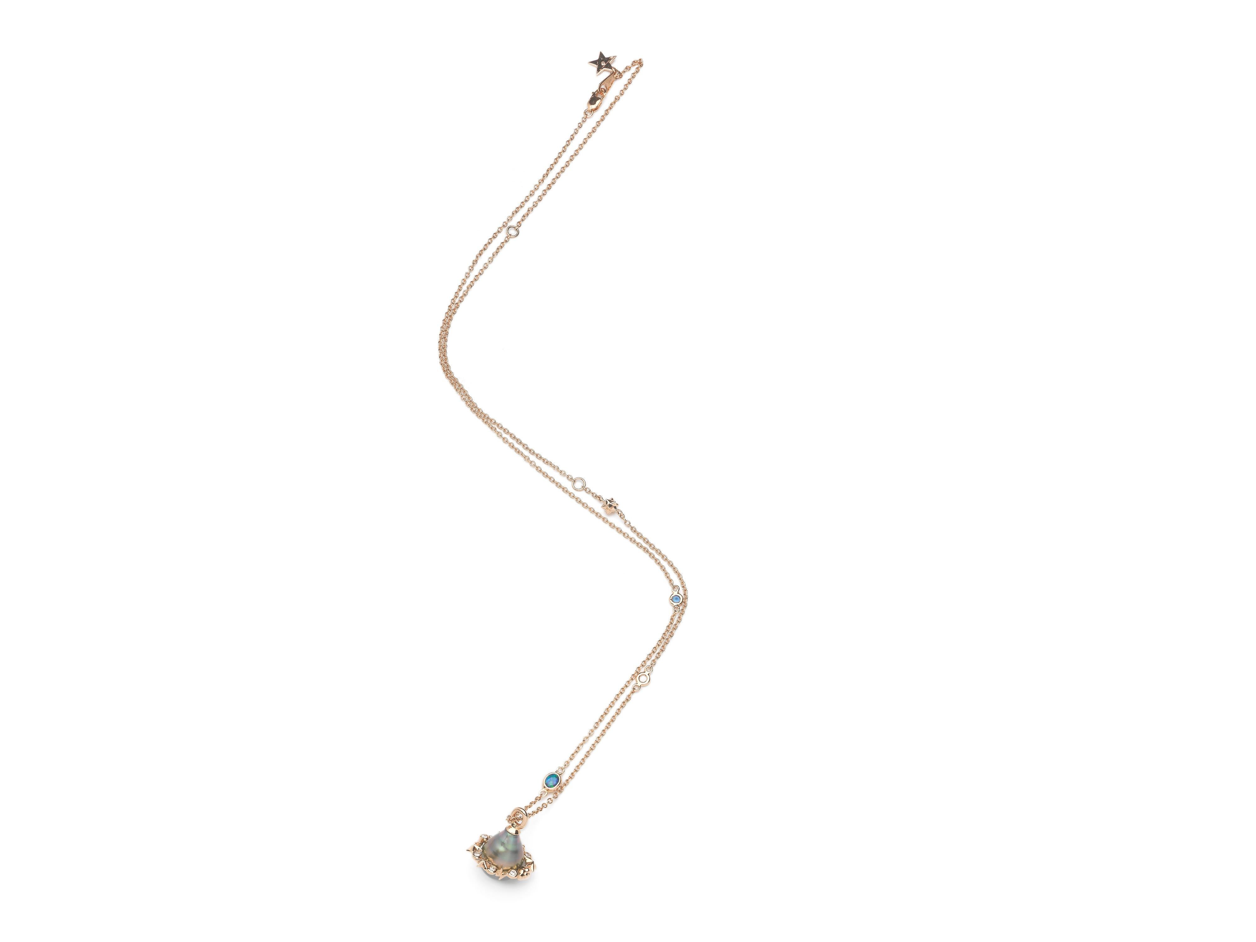 A beautiful petrol-blue, Tahitian pearl is the star of this necklace, with the pearl orbited by an 18k rose gold ring, that sparkles with white diamonds to resemble stars. The 18k rose gold chain is also set with white diamonds and blue sapphires