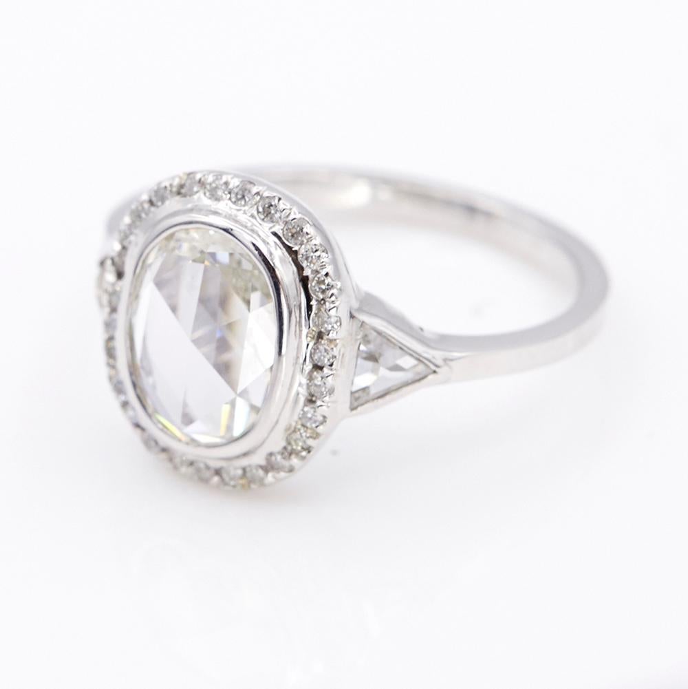 One of a kind ring from our Galaxy collection, made in 18k white gold with natural rose cut oval white diamond in the center, halo with round white diamonds, sides with triangle white diamonds, approx. 1.29ct. It's very low in profile and is very