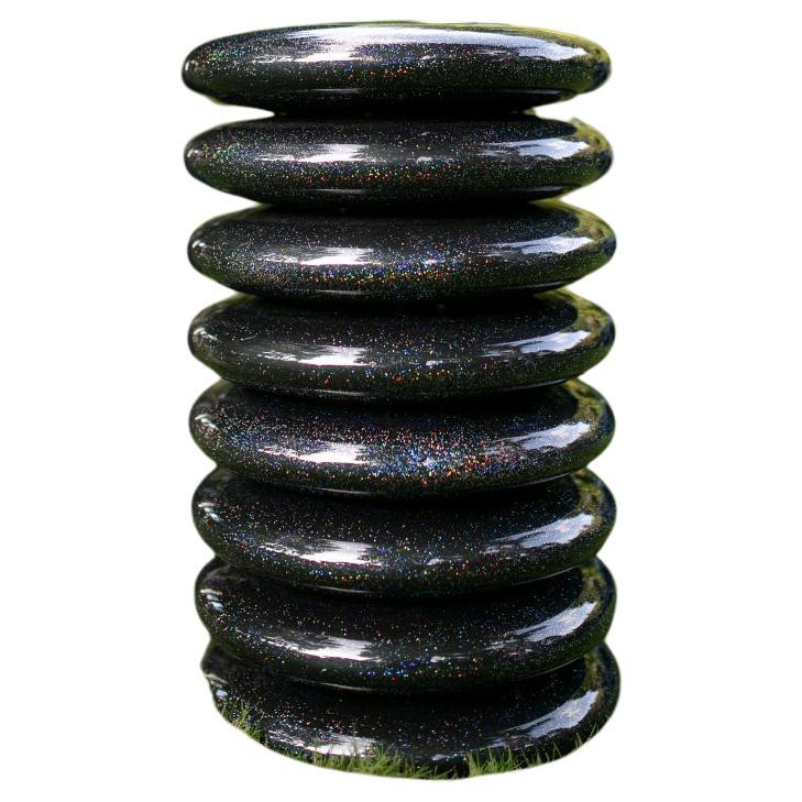The Galaxy pebble pouff seat by Kunaal Kyhaan is a stack of pebbles moulded in layers of fibreglass, balanced above each other to create a totemic tower. The fiberglass pebble has been airbrushed with a unique reflective glittery finish that