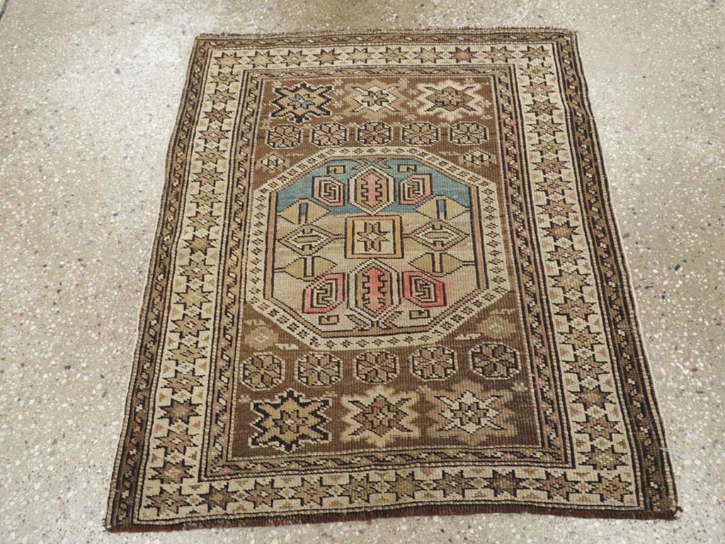 Esta alfombra caucásica Shirvan de principios del siglo XX, que mide 60 cm x 60 cm, es un sorprendente ejemplo del célebre arte de tejer de la región. La alfombra muestra un imponente medallón octogonal central flanqueado por motivos geométricos,