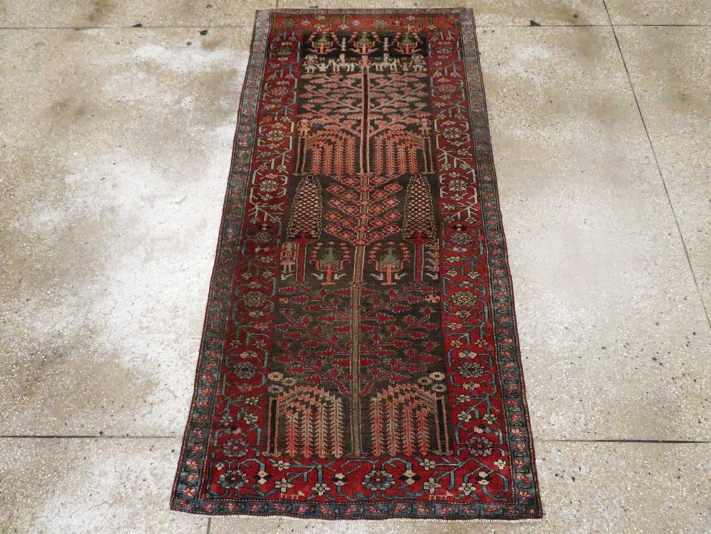 Ce tapis kurde persan du début du XXe siècle, mesurant 3 pieds 2 pouces sur 6 pieds 9 pouces, présente une composition richement expressive centrée sur le motif emblématique de l'