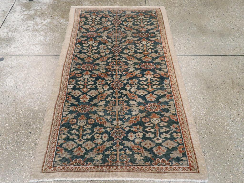 Un ancien tapis persan Mahal. Un fond bleu royal bien teinté présente un motif Gol Hennai allover à symétrie biaxiale, bien que les plantes à fleurs soient toutes orientées dans la même direction. Le treillis à losanges de feuilles et de fleurs est