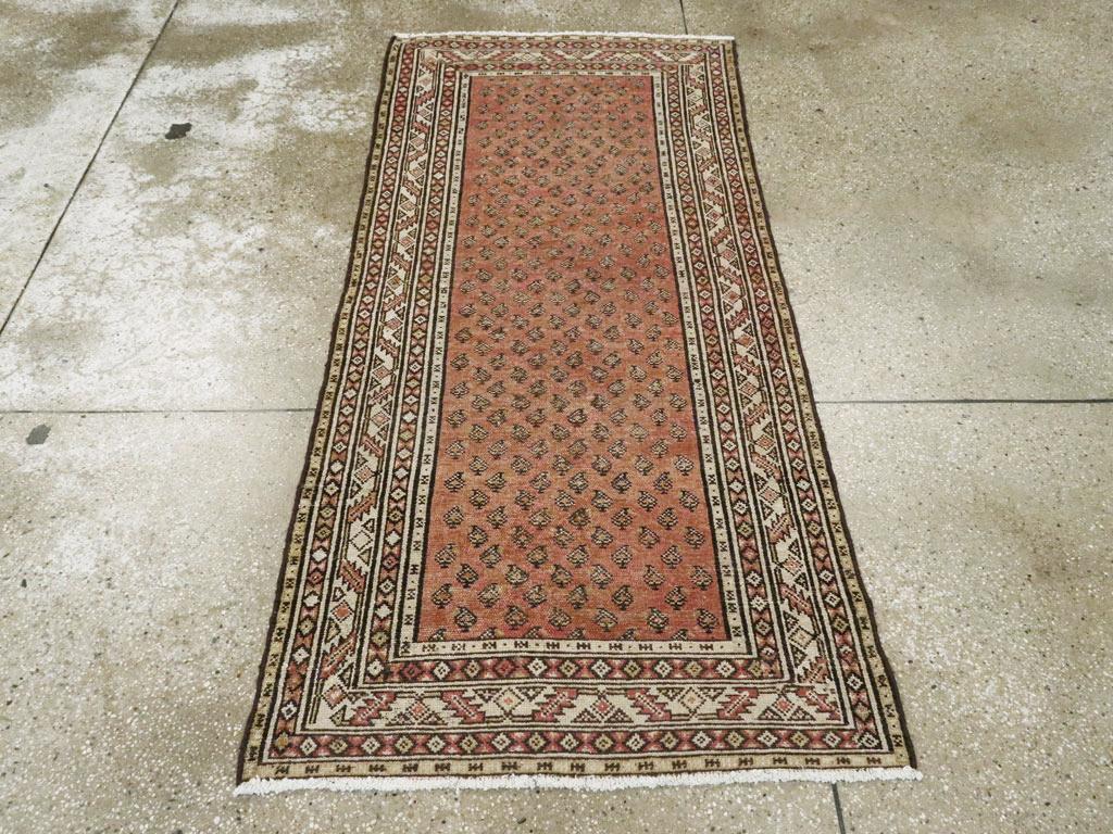 Esta alfombra persa Malayer de principios del siglo XX, de 1,80 m x 1,80 m, presenta un encantador diseño de boteh sobre un cálido fondo de terracota. Los motivos de cachemira repetidos -cada uno representado con sutiles variaciones- crean un patrón