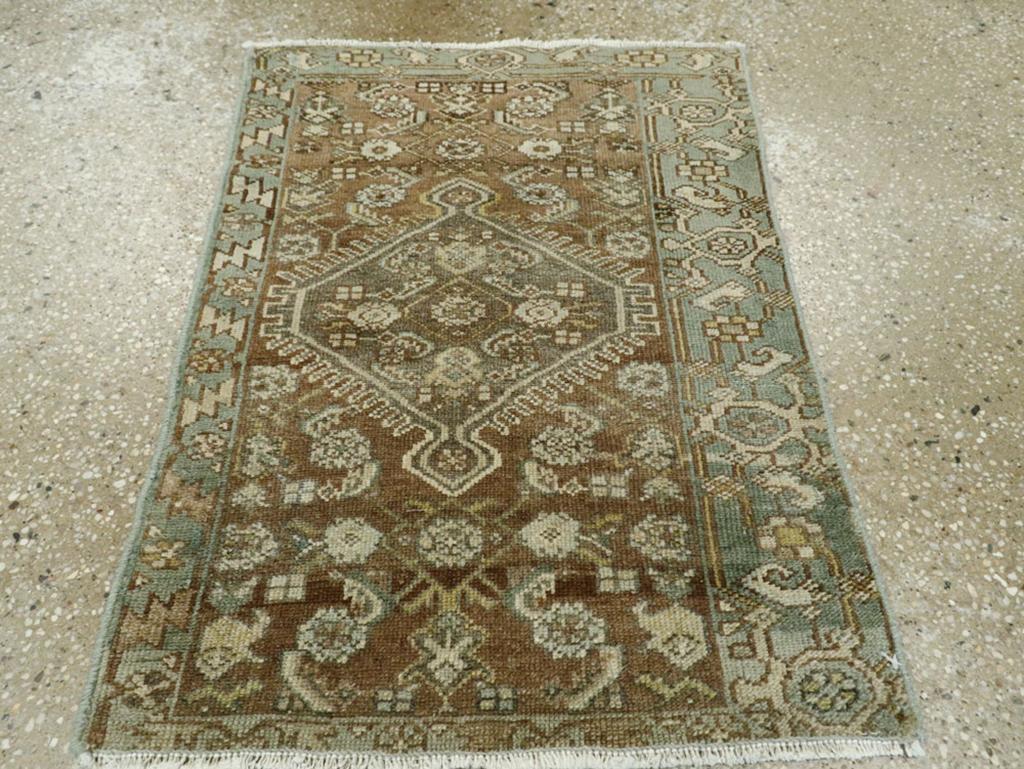Ce tapis persan Malayer du début du 20e siècle, mesurant 1+2=8] x 2+2=8], est un bel exemple de tissage villageois qui met en valeur le charme et le savoir-faire de l'artisanat persan. Le tapis présente un remarquable médaillon central en forme de