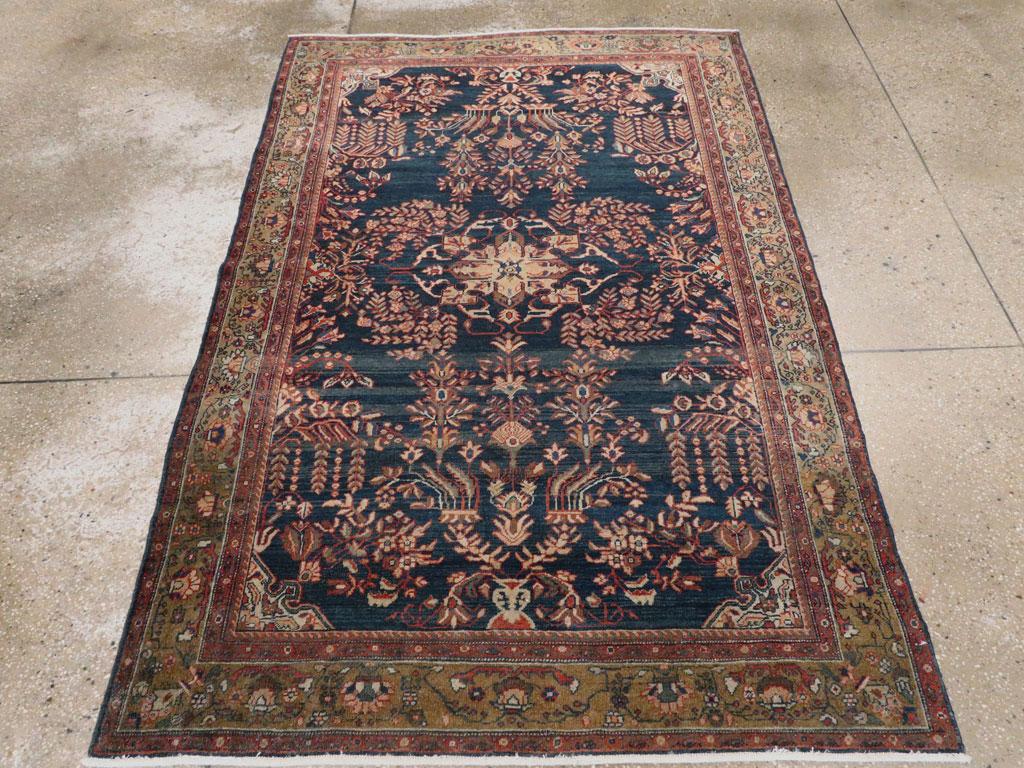 An antique Persian Sarouk Fereghan accent rug handmade during the early 20th century.

Measures: 4' 2