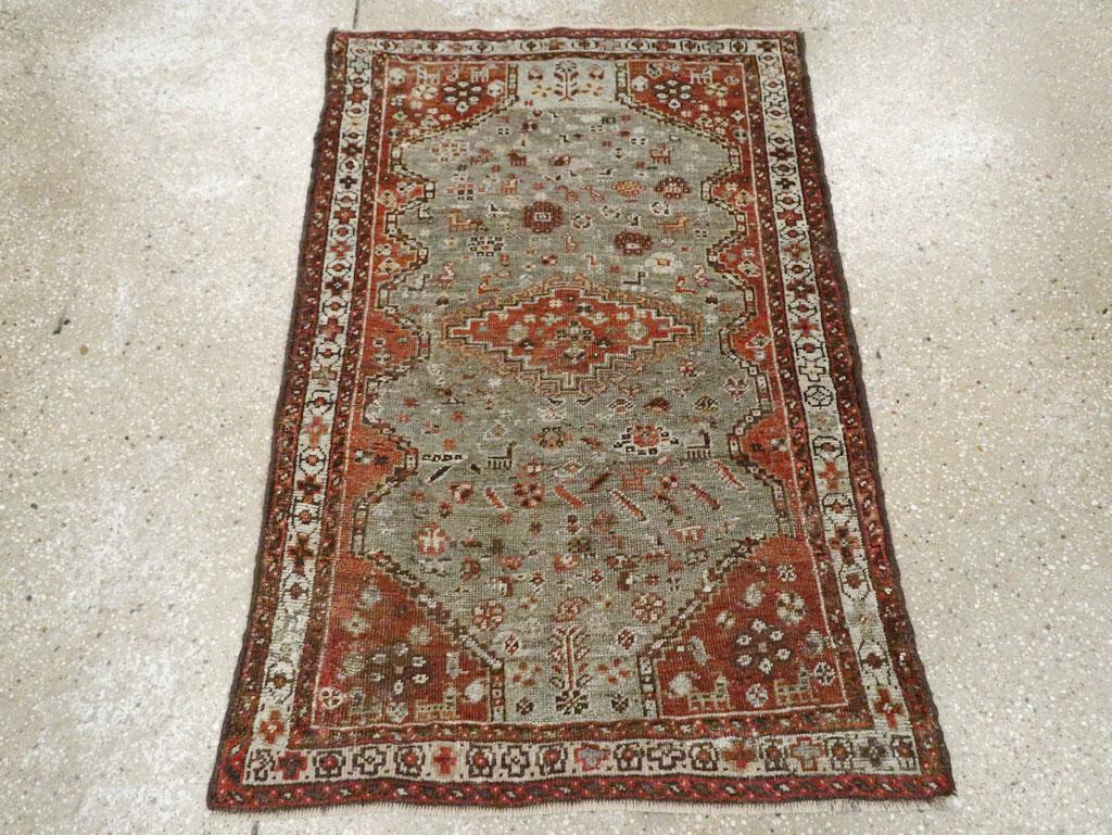 An antique Persian Shiraz throw rug. This ruglet with a blue-grey subfield adorned with stray animals and rosettes and set on a  similarly decorated rust field, within an ivory border of crosses alternating with open octagons. The rust medallion is