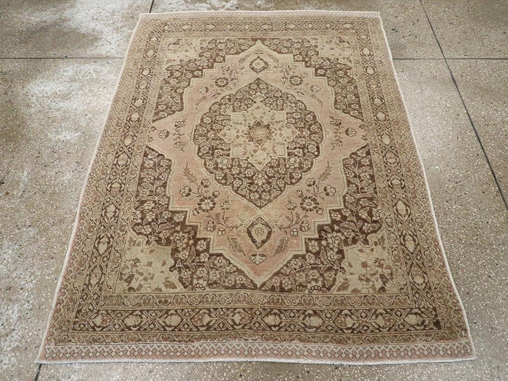 This Early 20th century Persian Tabriz rug, measuring 4' 1
