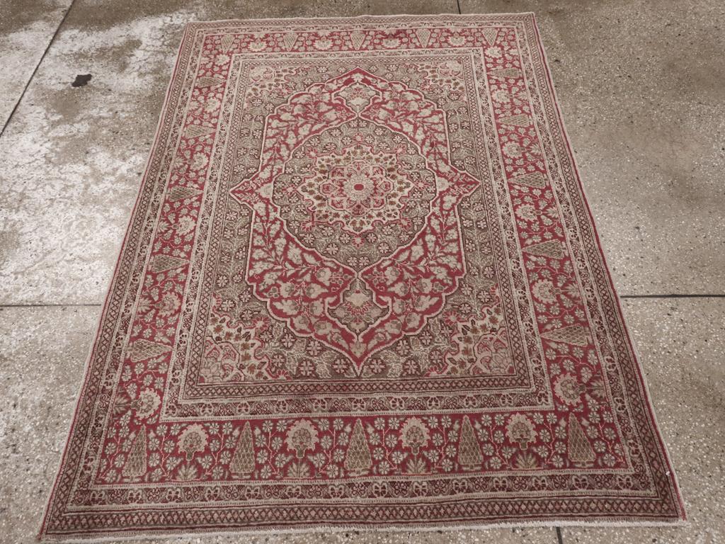 This Early 20th century Persian Tabriz rug, measuring 4' 0
