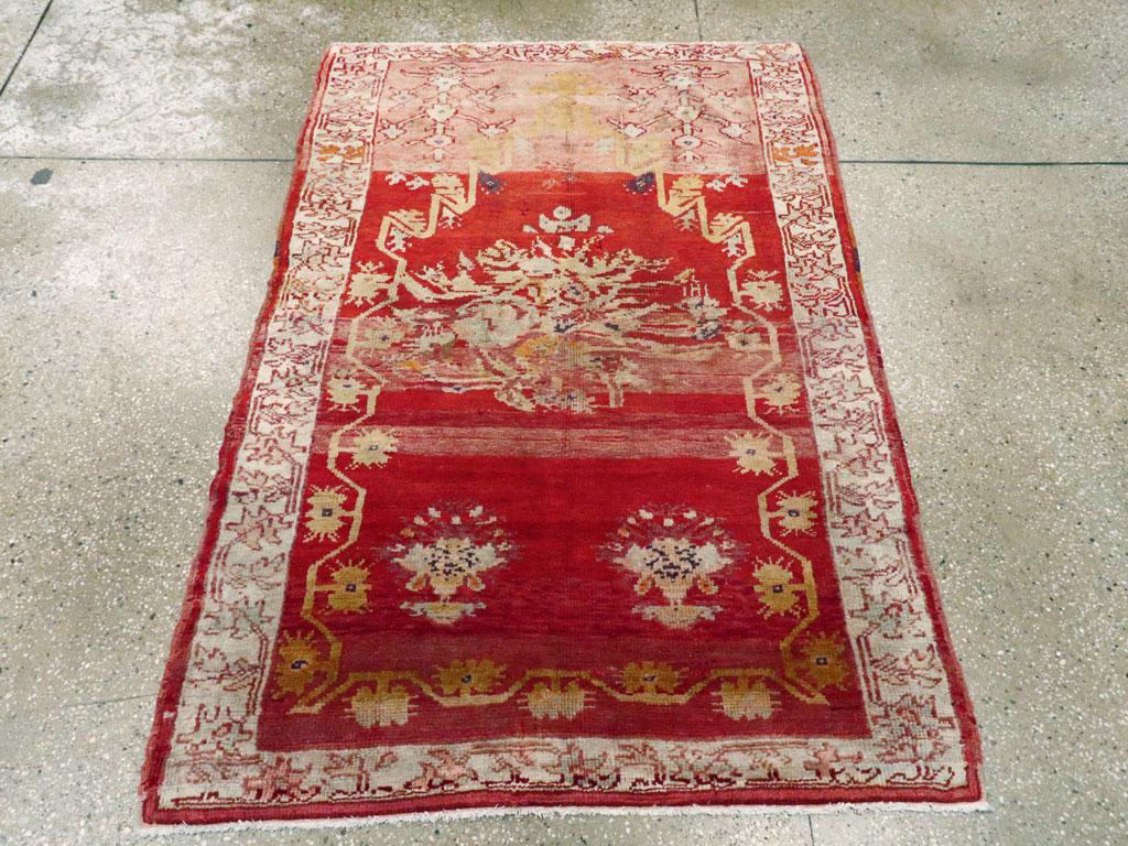Esta alfombra turca Oushak de principios del siglo XX, que mide 1,8 m x 1,8 m, presenta una paleta viva y una estética audaz emblemática del tejido de las aldeas de Anatolia. El campo está saturado de un intenso rojo rubí, que prepara el escenario