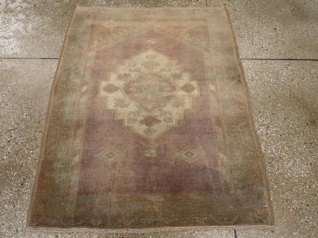 Esta alfombra Oushak turca de principios del siglo XX, de 1,80 x 1,80 m, presenta la paleta suave y atmosférica y la composición espaciosa características del tejido Oushak. El campo está representado en tonos lavanda y topo apagados, centrado por