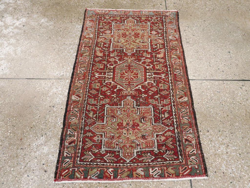 Una alfombra persa Karajeh vintage. Este clásico esparcidor de la periferia del distrito de Heriz, en el noroeste de Persia, muestra tres medallones característicos -dos octogramoidales y uno hexagonal con ganchos de marfil- sobre un fondo de
