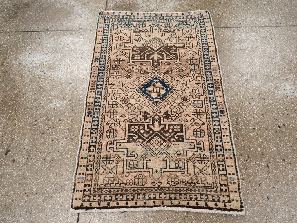 Ein alter persischer Karajeh-Teppich. Zwei charakteristische Oktogramme und ein hakenförmiger Diamant sind auf dem etwas abgewetzten beigen Feld dieser rustikalen, nordwestpersischen Streuung angebracht. Der Teppich hat eine helle Grundtönung, ohne