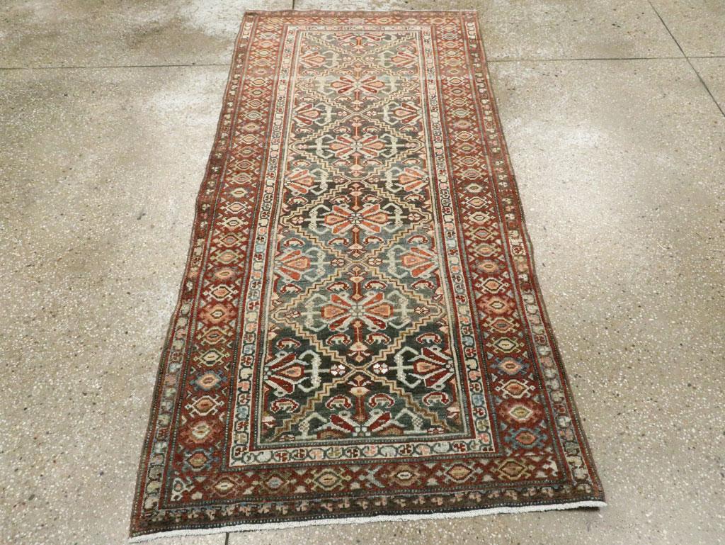 Esta alfombra persa Malayer de mediados del siglo XX, que mide 1,80 m x 1,80 m, presenta una audaz columna central de estilizados medallones florales dispuestos en un entramado de rombos. El suave campo azul pizarra raspado está enmarcado por