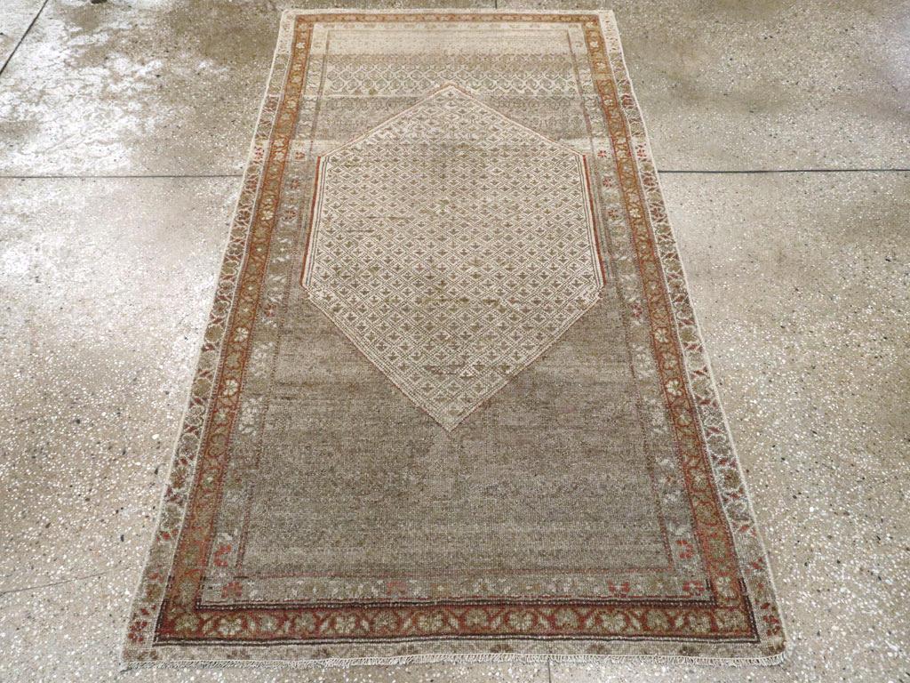 Esta alfombra persa Malayer de mediados del siglo XX, que mide 1,80 m x 1,80 m, presenta un diseño refinado y discreto anclado por un gran medallón central en forma de rombo. El interior del medallón está relleno de un delicado entramado romboidal
