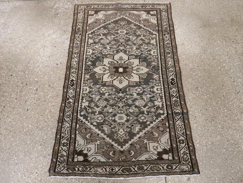 Una alfombra persa Malayer vintage. Este rústico esparcidor persa occidental muestra un motivo Herati allover delimitado sobre un fondo hexagonal de pizarra con un medallón central beige.  Los botines con pie que parecen caballeros de ajedrez y las