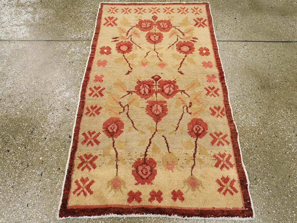 Ein türkisch-anatolischer Teppich im Vintage-Stil. Der alte elfenbeinfarbene Grund zeigt ein doppeltes Modul mit jeweils fünf stilisierten rosafarbenen Rosen (eine zusätzliche Rose befindet sich am unteren Rand) und hellgrünen Blättern innerhalb