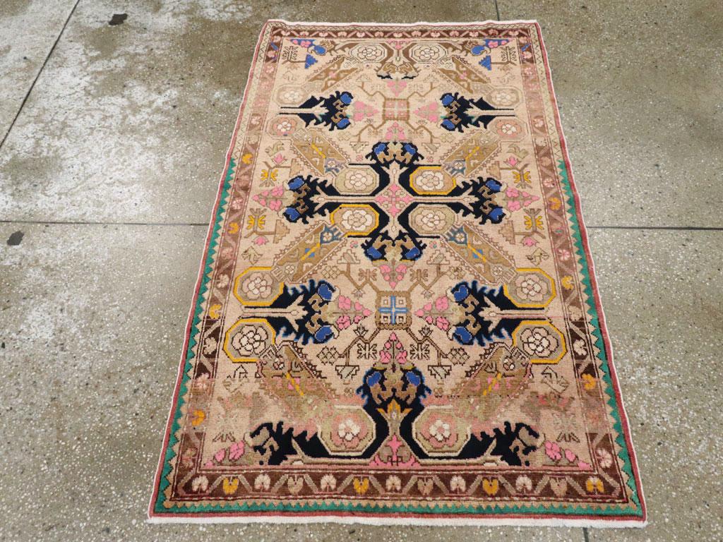 Esta alfombra turca de Anatolia de mediados del siglo XX, que mide 1,80 m x 1,80 m, presenta un dinámico diseño geométrico en medallón con una atrevida simetría y vivos contrastes de color. El suave campo beige proporciona un tranquilo telón de