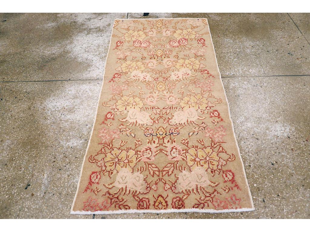 Esta alfombra turca de Anatolia de mediados del siglo XX, que mide 1,80 x 1,80 m, presenta una paleta suave y romántica y una graciosa disposición floral característica de la producción de los talleres regionales de este periodo. El campo beige está
