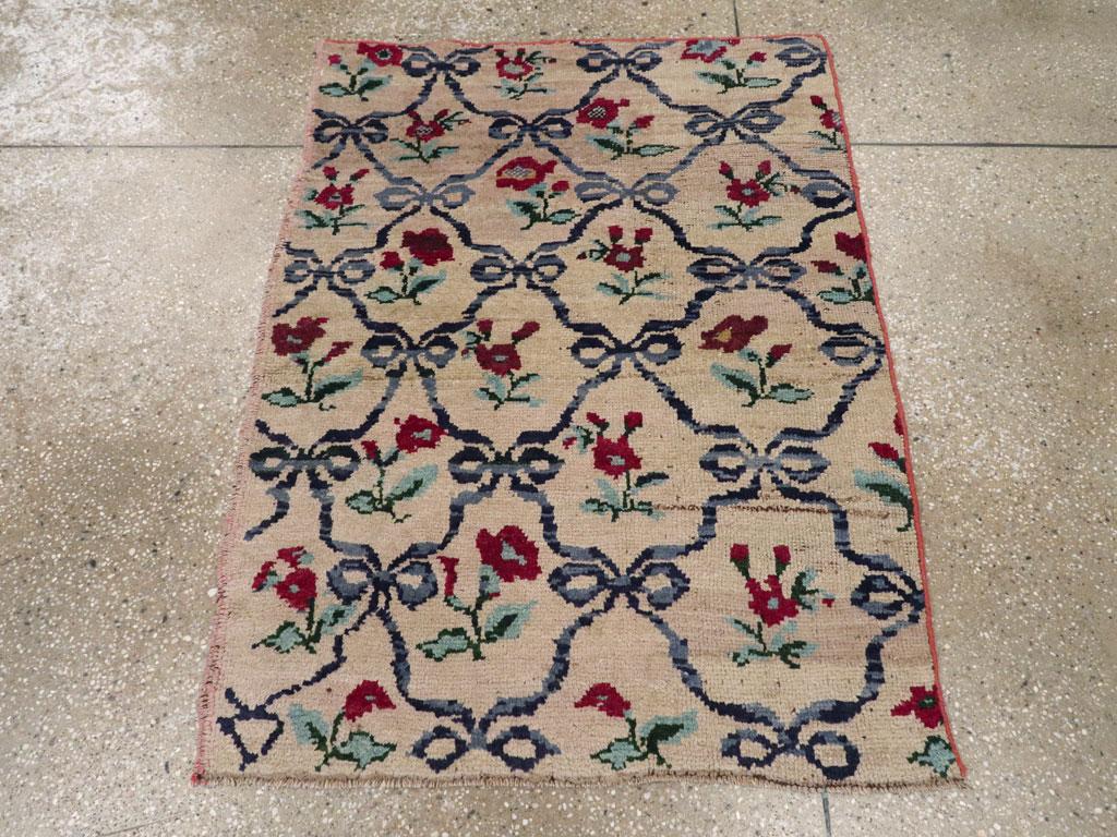 Esta alfombra turca de Anatolia de mediados del siglo XX, que mide 1,8 m x 1,8 m, presenta un encantador diseño de celosía floral impregnado de carácter folclórico. El campo en tono marfil se organiza en un patrón de enrejado repetitivo formado por
