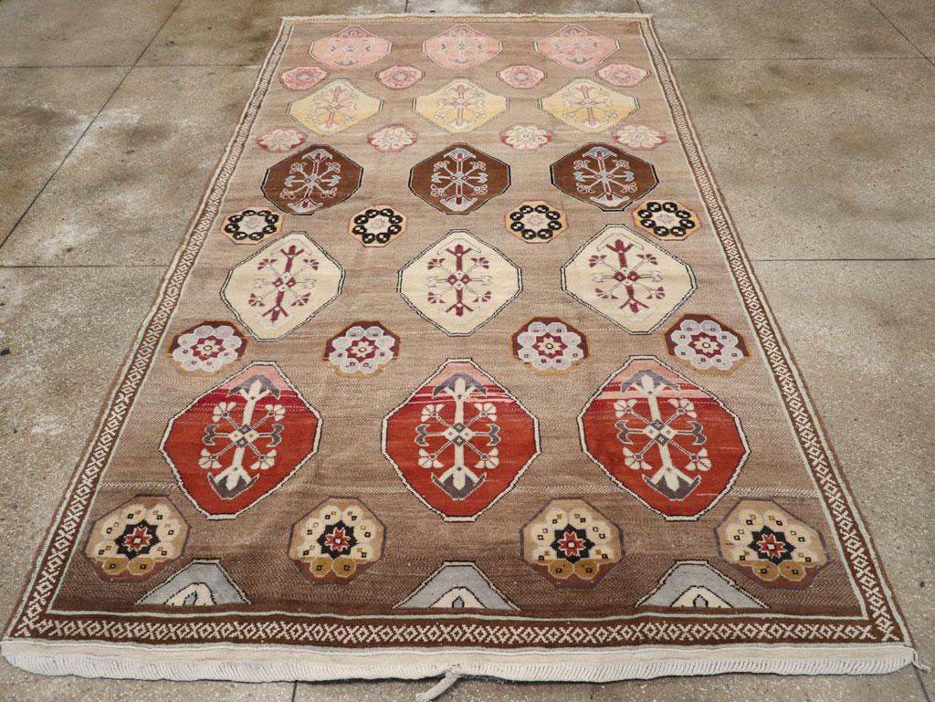 This mid-20th century Turkish Anatolian tribal room-size carpet, measuring 7' 2