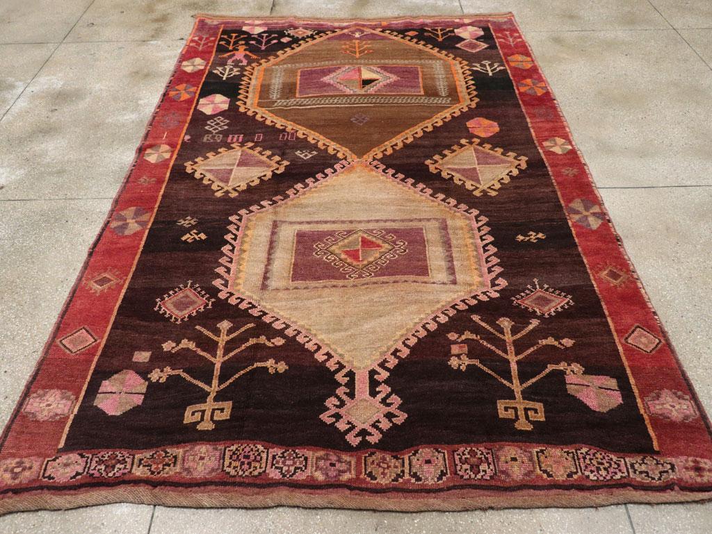 This mid-20th century Turkish Anatolian tribal carpet, measuring 7' 9