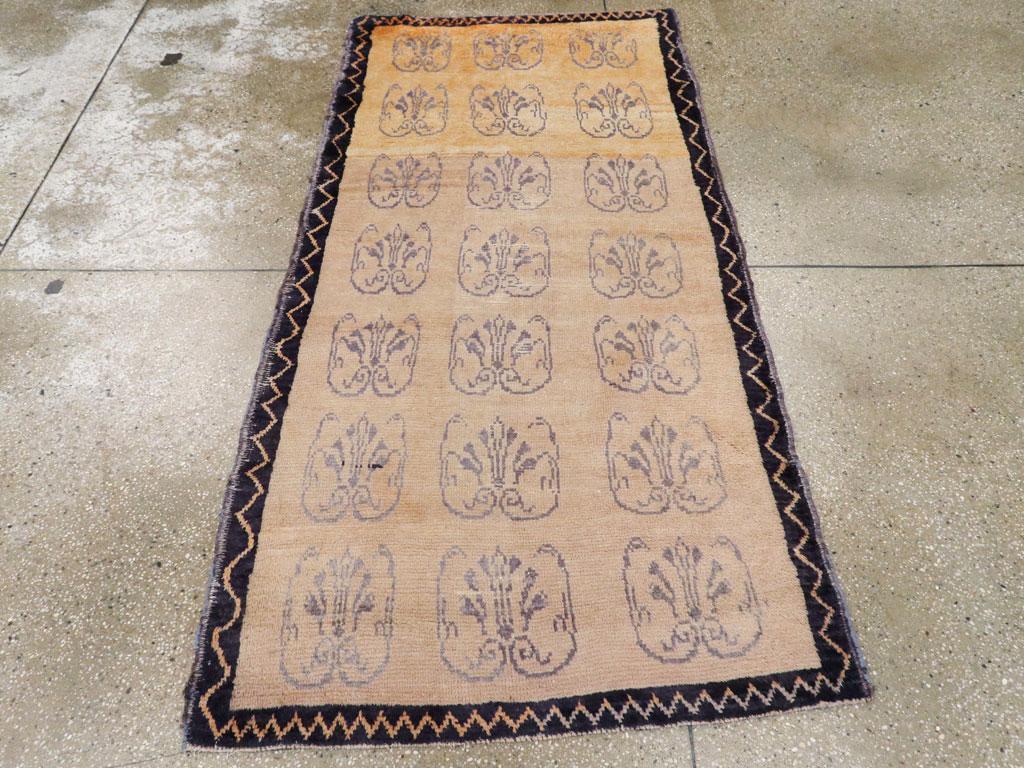 Un tappeto vintage turco Konya. Un'abrasione  Il fondo in avorio antico presenta tre colonne di sette palmette blu traforate e  sottili foglie a parentesi, il tutto all'interno di uno stretto bordo a zig-zag color carbone. Il motivo sembra avere