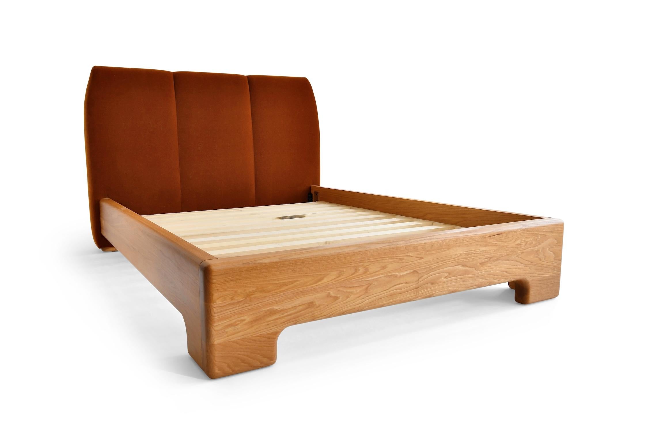 The Gallatin Bed with its sleek Mid-Century Modern silhouette, upholstered headboard and sculpted solid wood frame is a masterful blend of contemporary design. A stunning composition of wood grain flow that conveys an artistic sense of warmth and