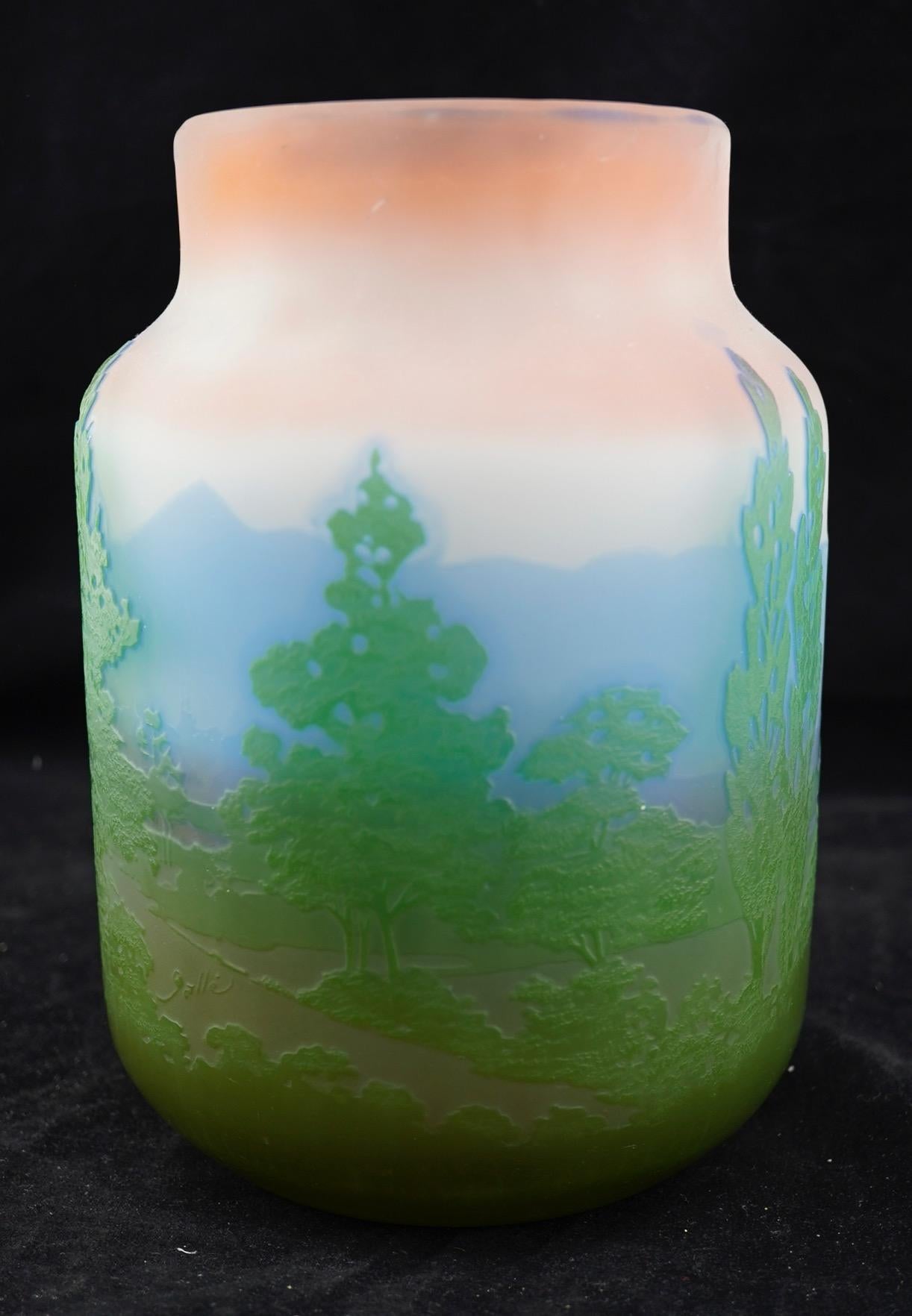Galle cameo Alpine landscape vase in frosted pink glass, decorated with a green intercalaire tree scene over a blue mountain range. At least 3 glass layers. Signed in cameo with 