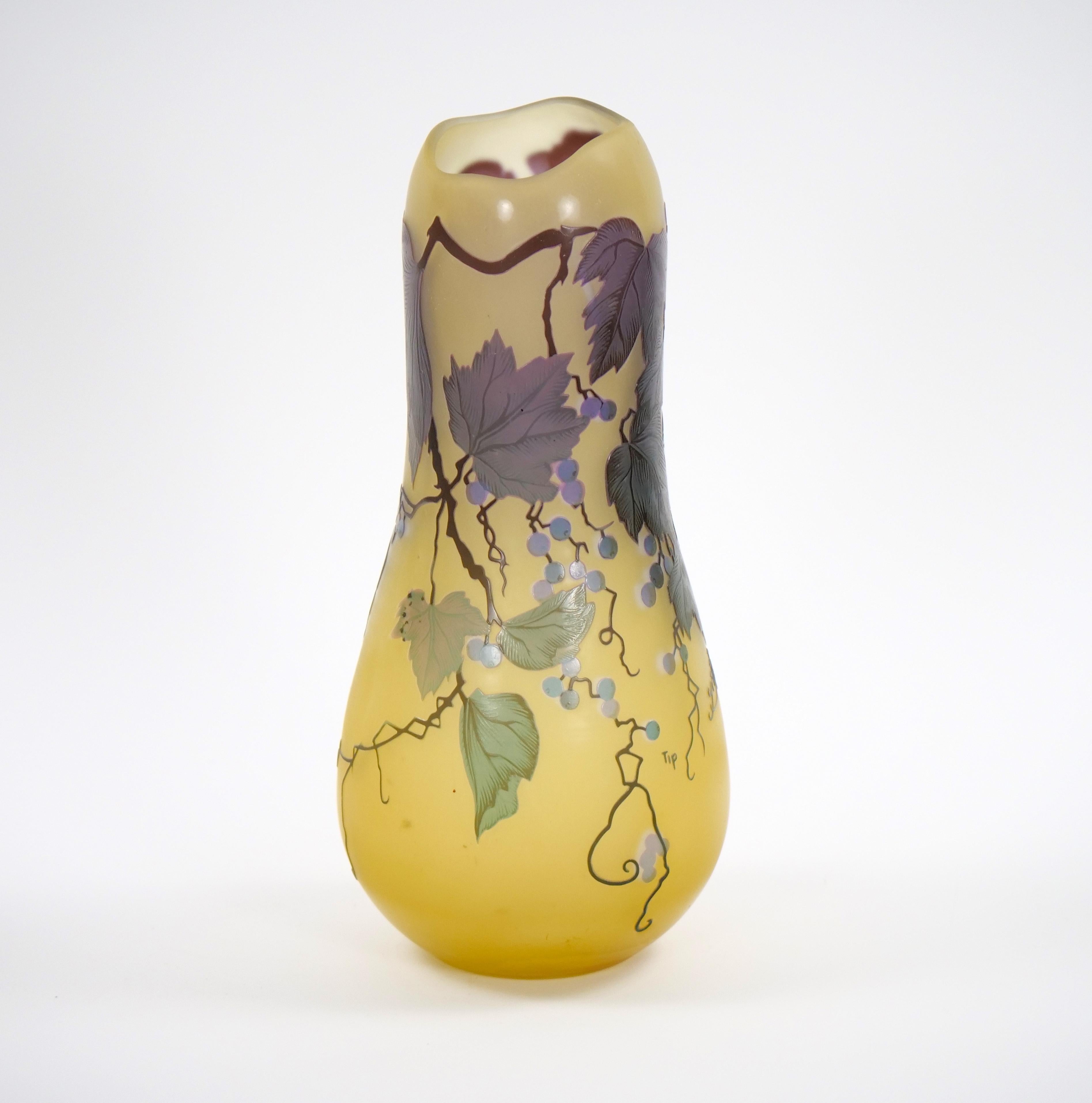 A lovely gourd shaped cameo glass vase in the Art Nouveau style featuring violet colored flowering berry vines on a yellow ground.  13 1/2 by 5 1/2 inches and in very good condition.  Signed Galle.