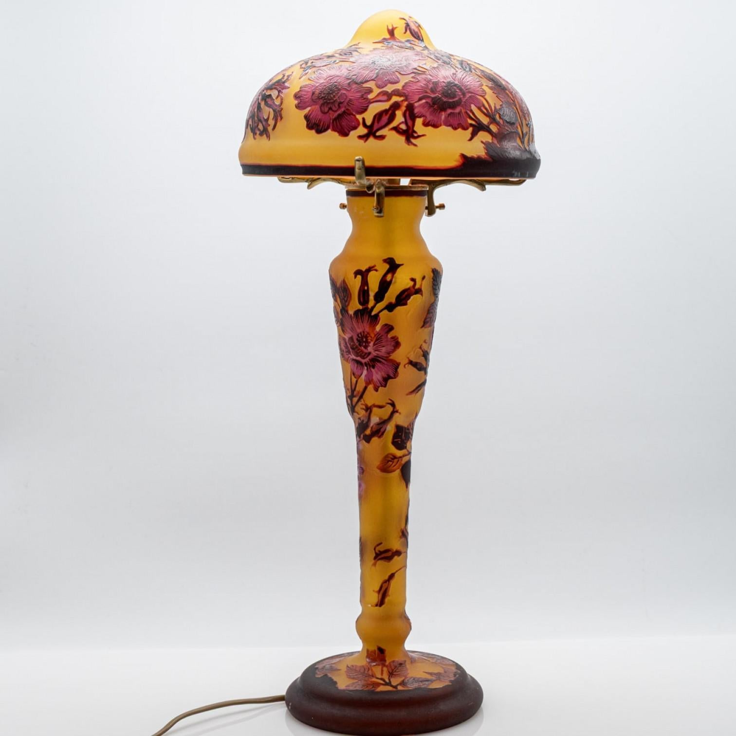 Esta exquisita lámpara de sobremesa Gallé de estilo Art Nouveau es todo un reclamo. Fabricado en Francia, al estilo del movimiento Art Nouveau 1970.

La lámpara de mesa, con forma de seta, es de cristal de color amarillo con flores rojas.


