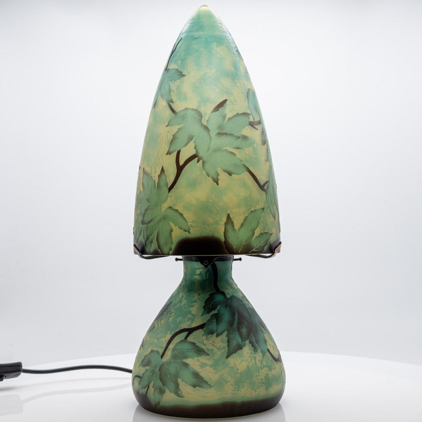 This exquisite Art Nouveau Gallé table lamp is a real eye catcher. Made around 1900 in France.

The table lamp, shaped as a mushroom, is made of green colored glass with leafs on it.

Émile Gallé was a French glass maker and furniture designer based