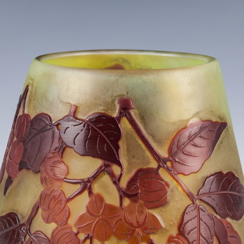 An ovoid Galle cameo vase with cherry blossom with wine red leaves and apple red blossoms over an orange-amber base
Signed Gallé,
circa 1900.

 