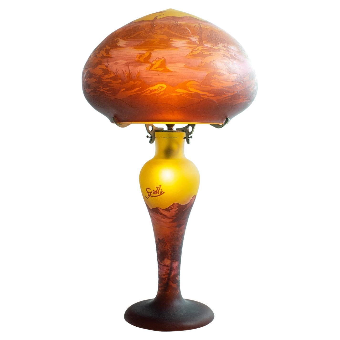 Gallè Tip - Unusual Large Art Nouveau Mushroom Lamp in multilayer glass

Impressive Mushroom Lamp decorated with a landscape scene of mountains, river and trees, tones of pink on an ocher background. In working order.

Height: 60cm.  Lamp and base